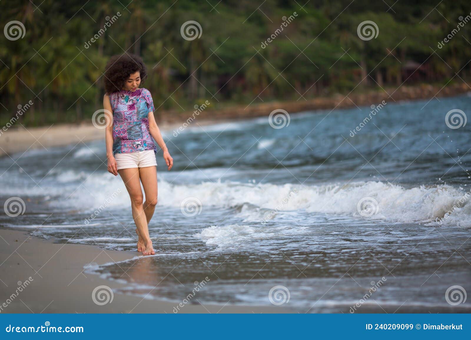 Una Mujer Mixta En La Línea De Surf Camina Por Una Playa De Mar En El  Trópico. Imagen de archivo - Imagen de vacaciones, actividad: 240209099
