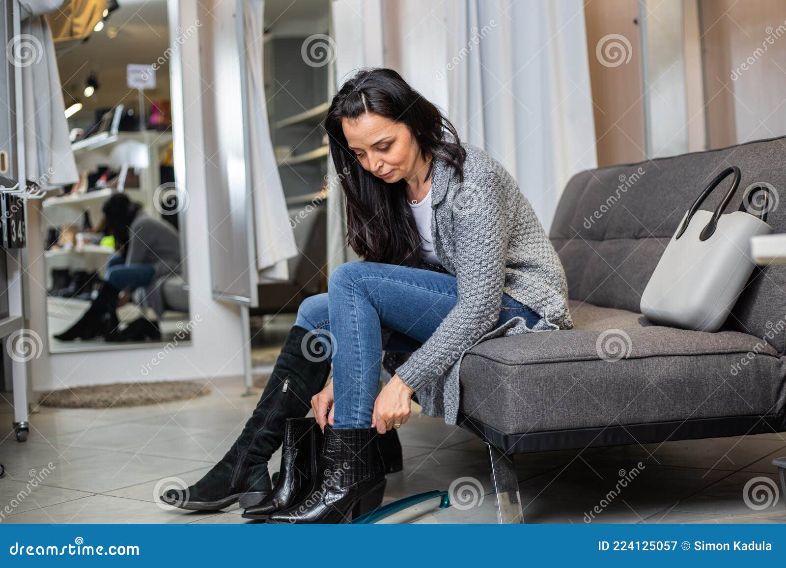 Una Mujer Muy Joven Tratando De Escoger Los Zapatos O Botas Correctos En El  Concepto De La Tienda De Ropa Imagen de archivo - Imagen de manera,  minorista: 224125057