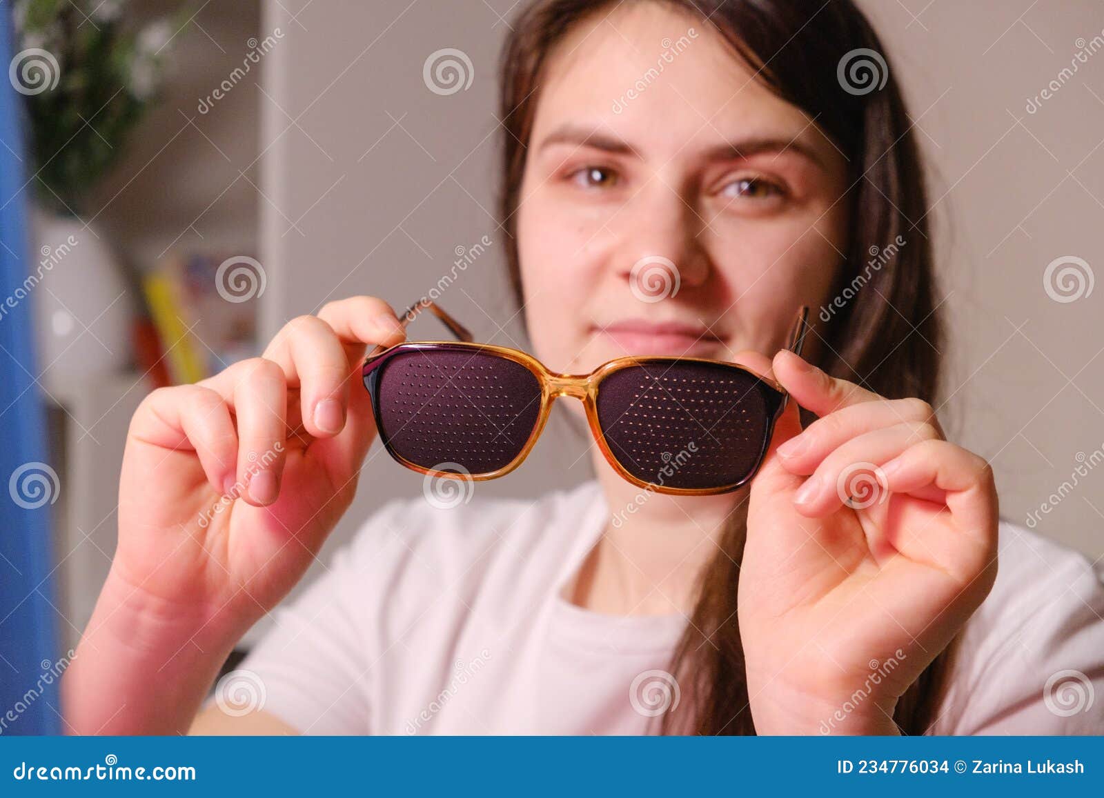 Una Mujer Sujeta Gafas De Perforación Para Corregir Una Deficiencia Visual.  Foto de archivo - Imagen de entrenamiento, sunglasses: 234776034
