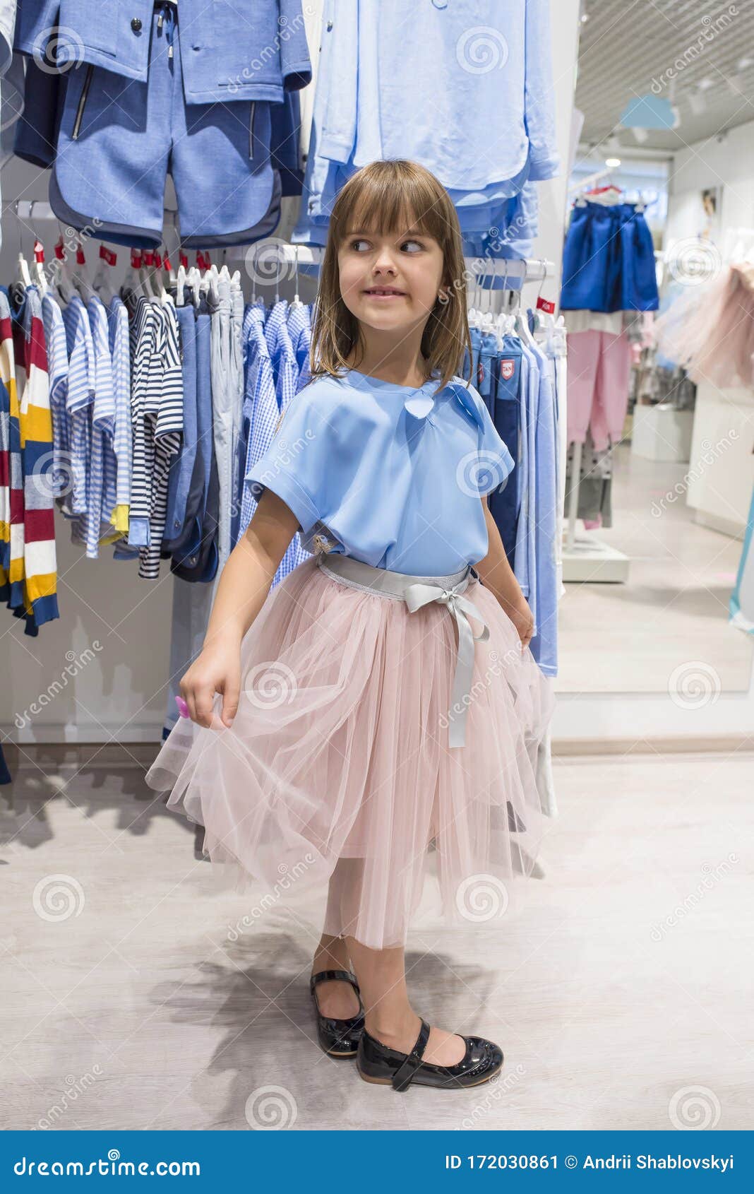 Una Niña Pequeña En Una De Ropa Elige Un Vestido Compras Imagen de - Imagen de ocasional, lindo: 172030861