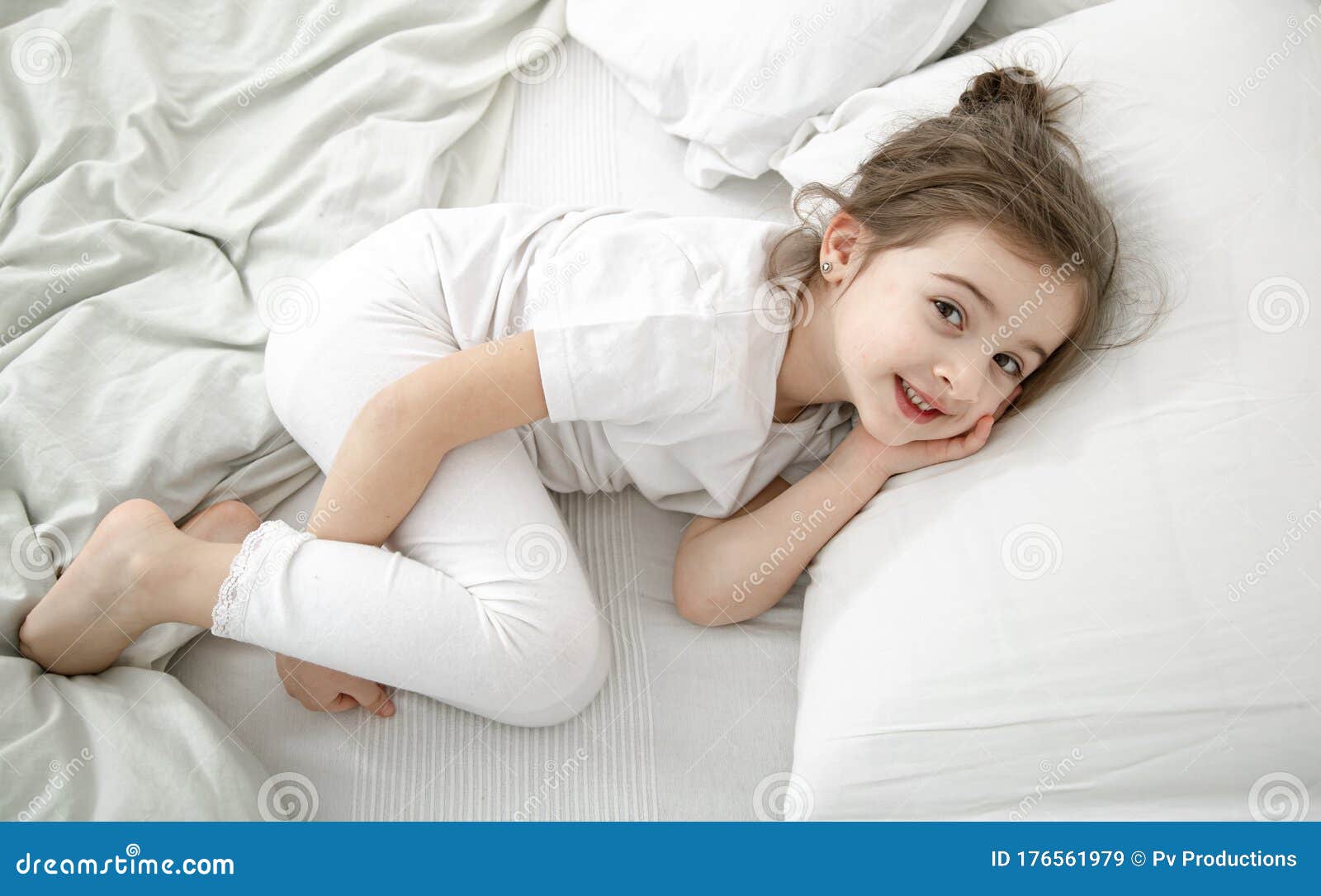 Una Niña Linda Duerme En Una Cama Blanca Imagen De Archivo Imagen De