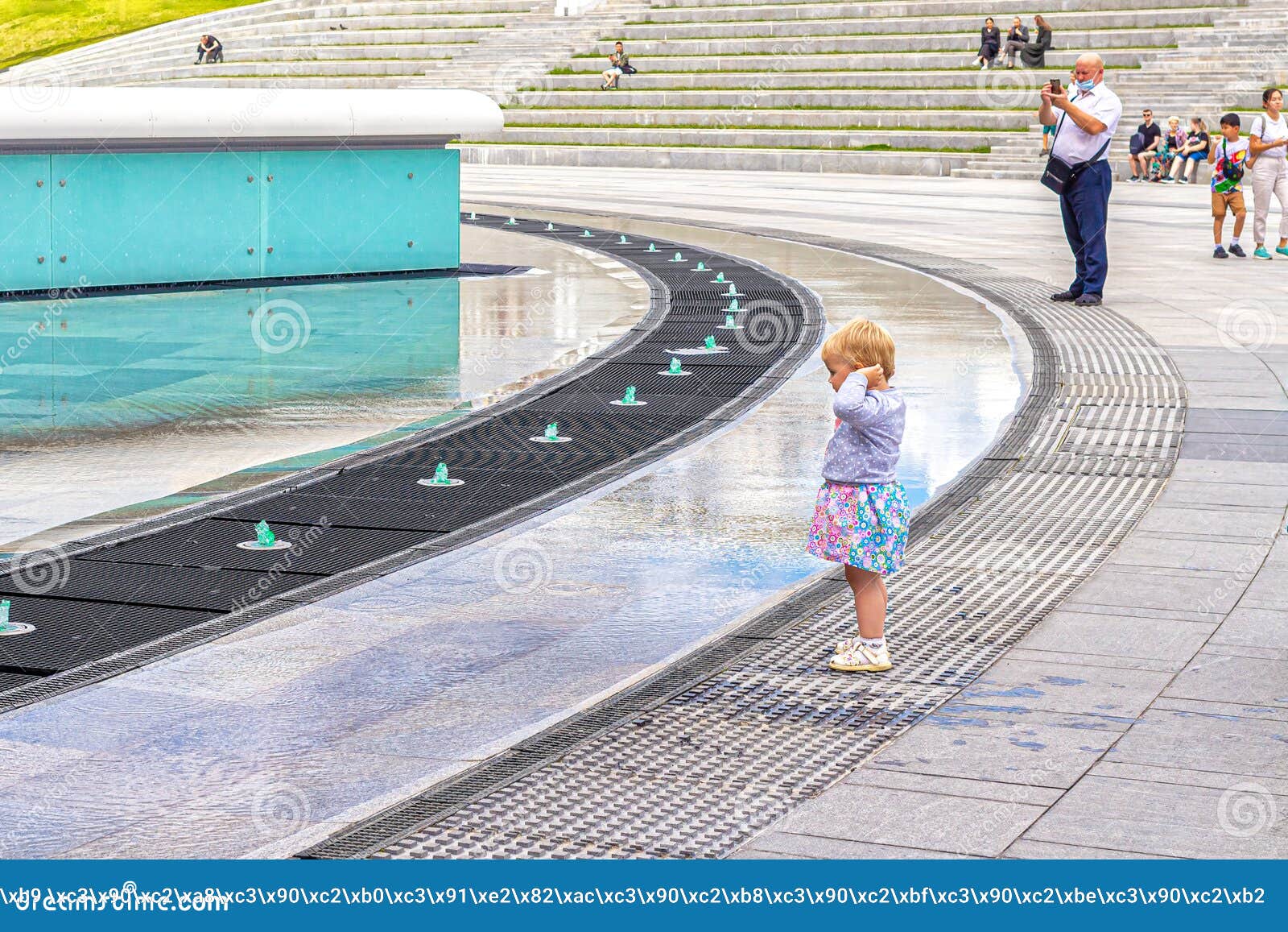 Una Niña Pequeña Mira Los Chorros De Agua En Una Fuente Ligera Y