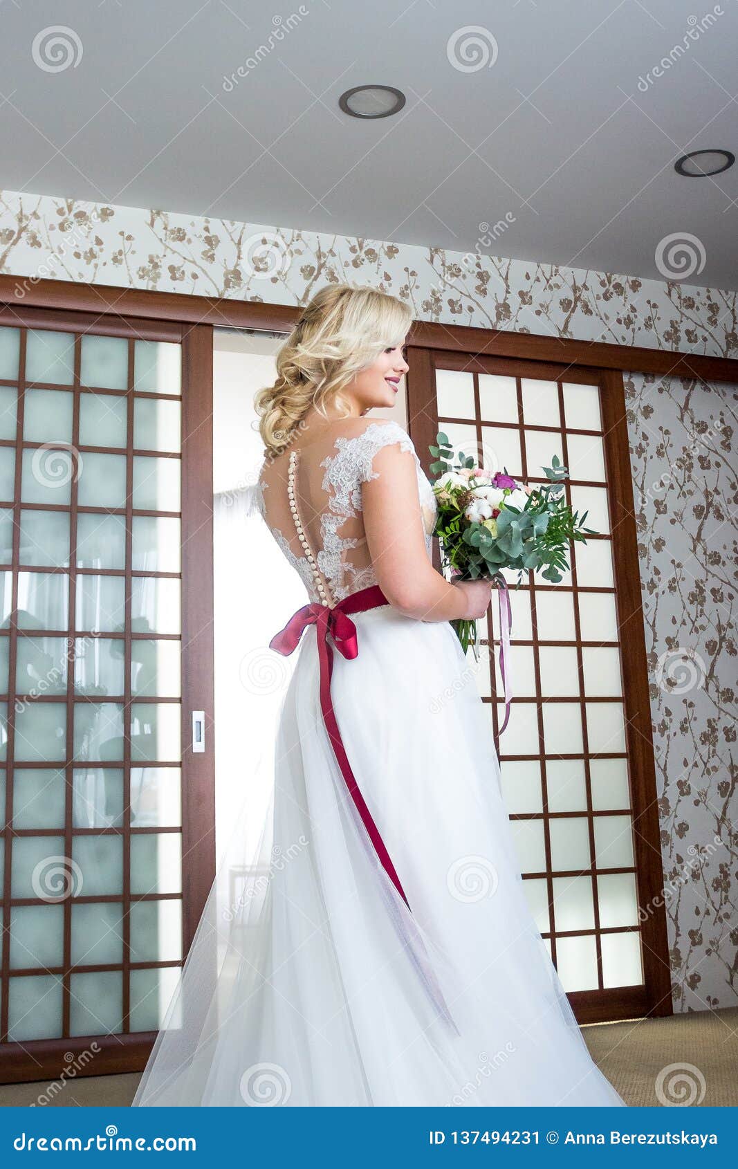 Una Novia Con Los Soportes Del Maquillaje Y Del Peinado En Una Habitación En Un Vestido Que Se Casa Con Una Cinta Roja Y Con Un R Imagen de archivo - Imagen Una Novia Con Los Soportes Del Maquillaje Y Del Peinado En Una Habitación En Un Vestido Que Se Casa Con Una Cinta Roja Y Con Un R Imagen de archivo - Imagen