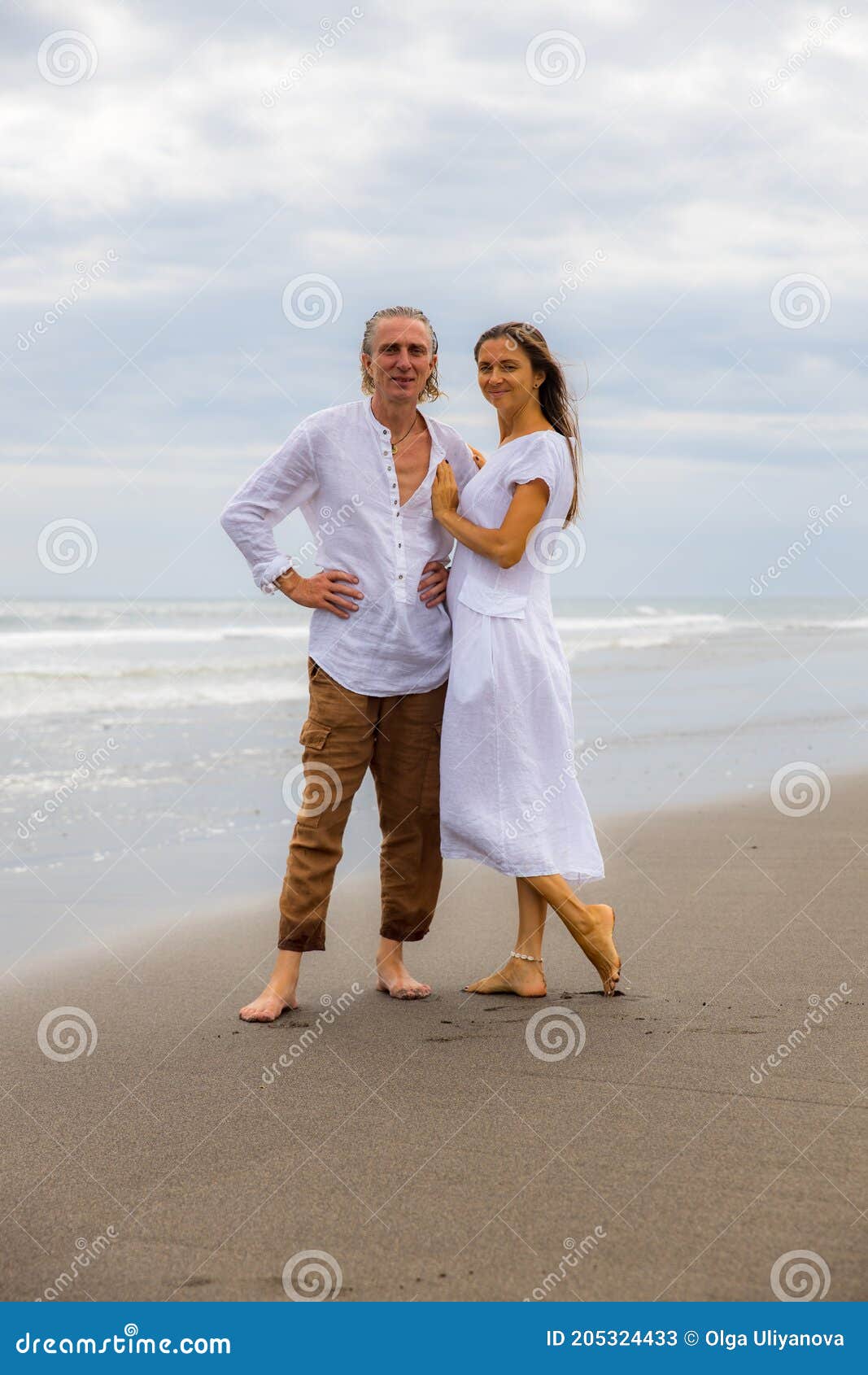 Pareja Caminando Descalzo Por La Hombre Con Pantalones Marrones Y Camisa Blanca. Mujer Vestida De Blanco. Marido Y Muje Imagen de archivo - Imagen de tarde, 205324433
