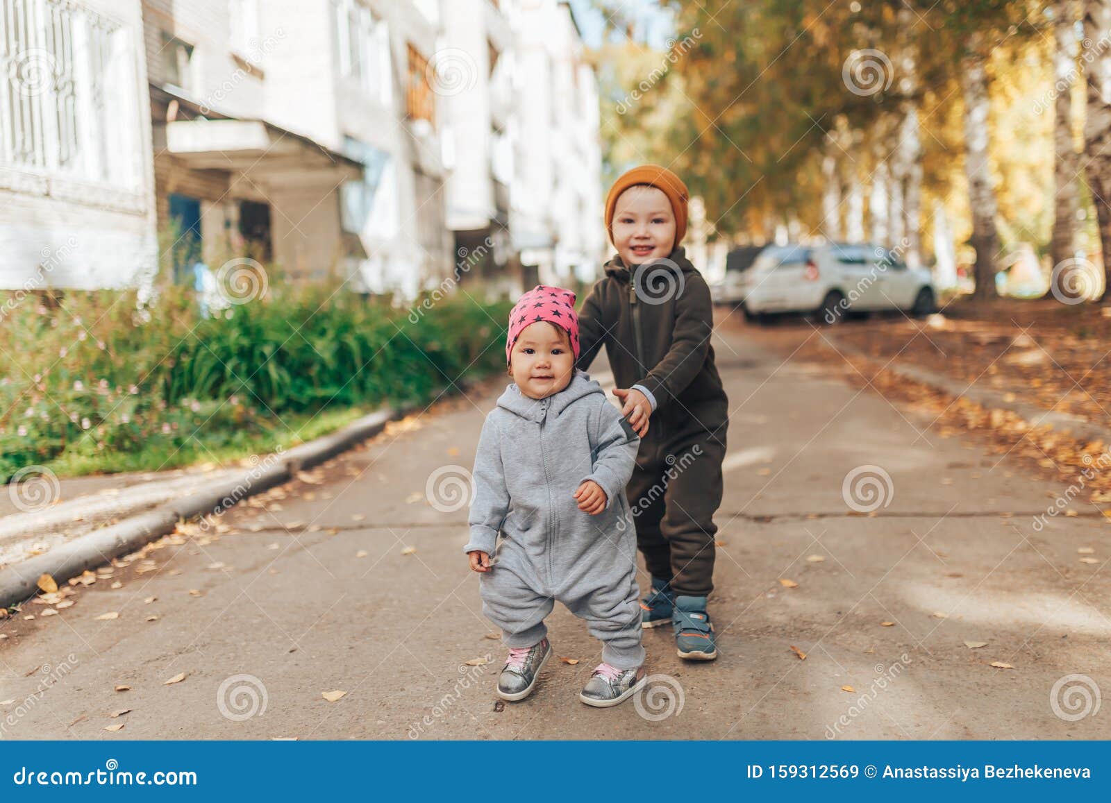 Una Pequeña Niña De 1 Año Y Un Niño De 3 Años Caminando Al Aire Libre Con  Ropa En Elegantes Vestíbulos Imagen de archivo - Imagen de hermoso, hierba:  159312569