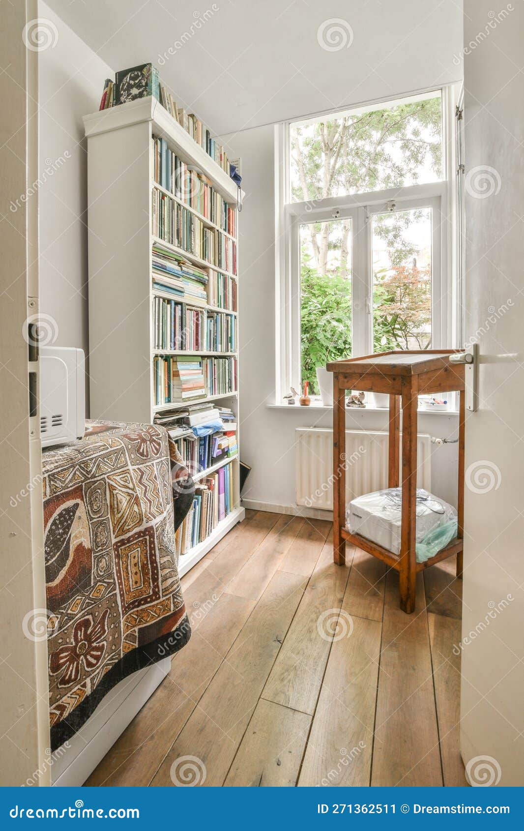 Una habitación con un estante para libros y una ventana con un