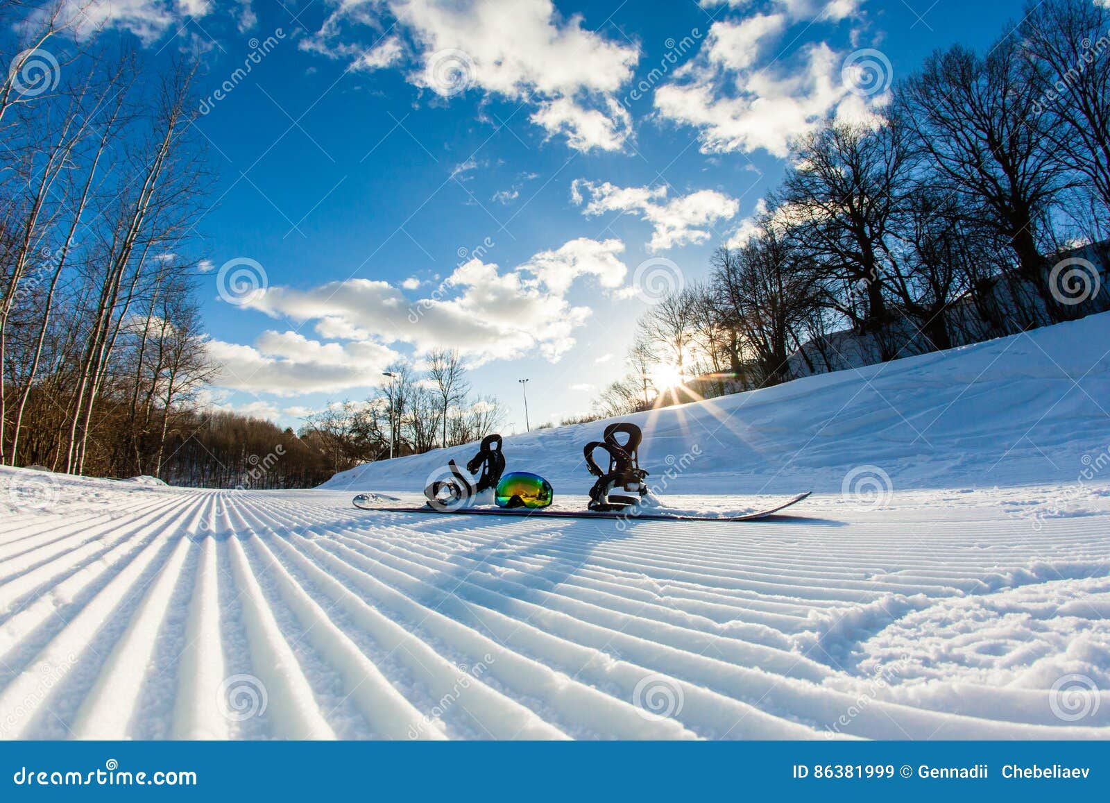 unbroken ski slope, snowboard and goggles
