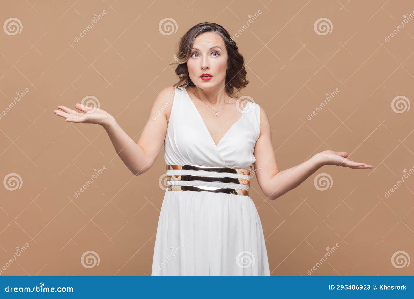 uncertain woman shrugging shoulders, keeps palms sideways, has questioned perplexed face expression.