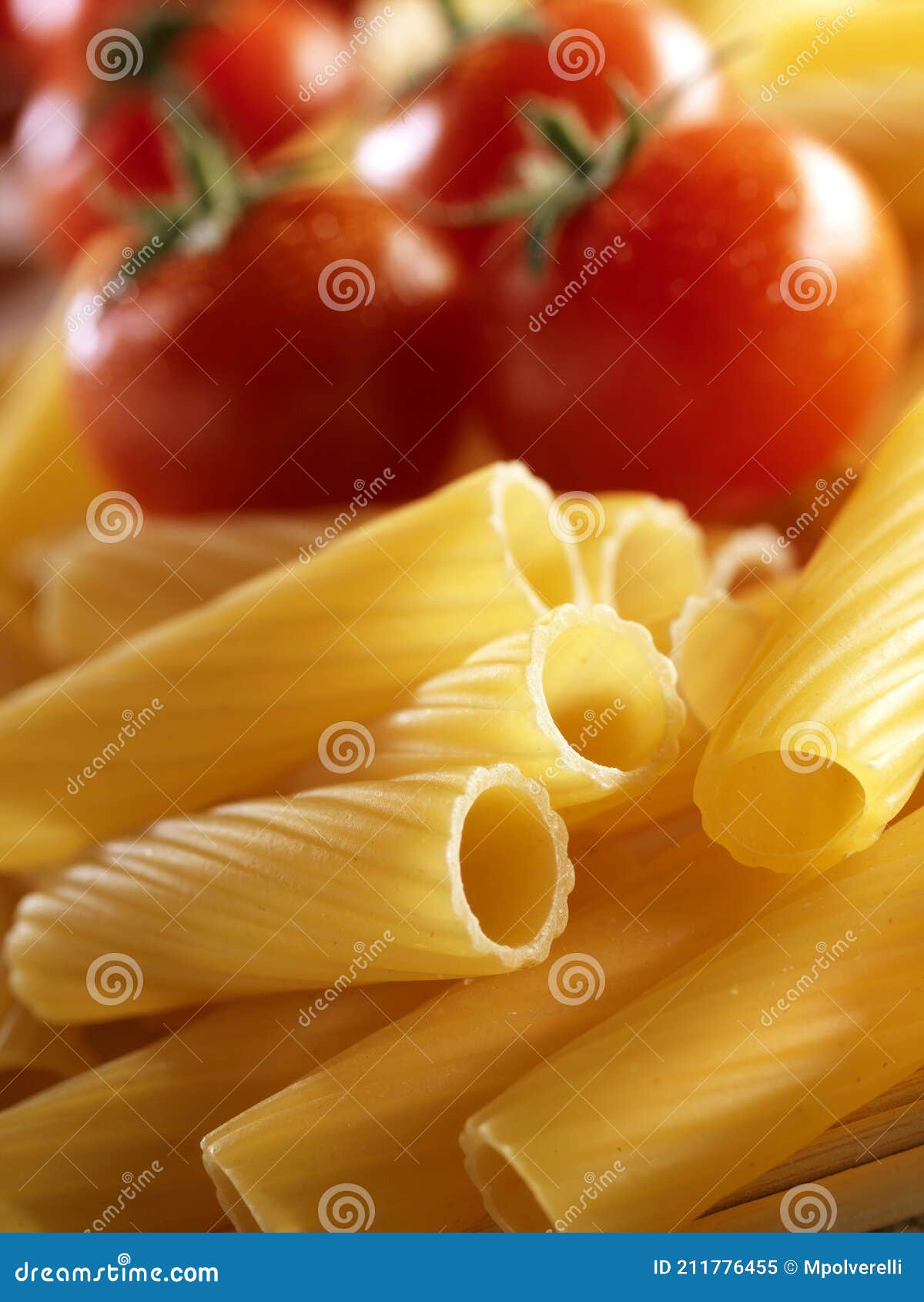 unckoked pasta on white background with tomato