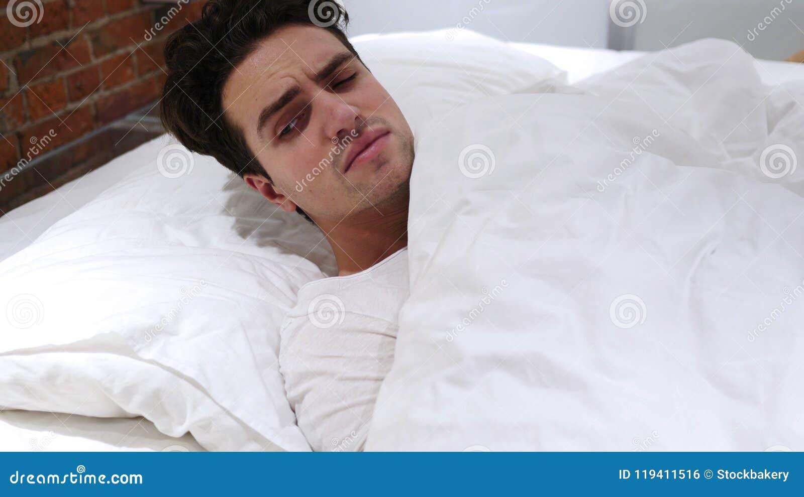 Man Sleeping in Bed at Night, Restlessness Stock Photo