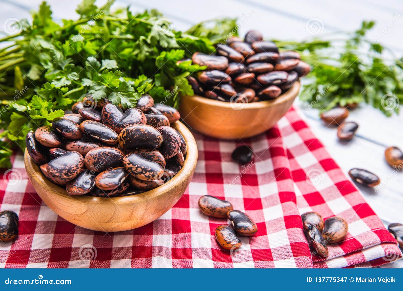 Uncooked Beans in Wooden Bowles with Parsley Herbs on Kitchen Table