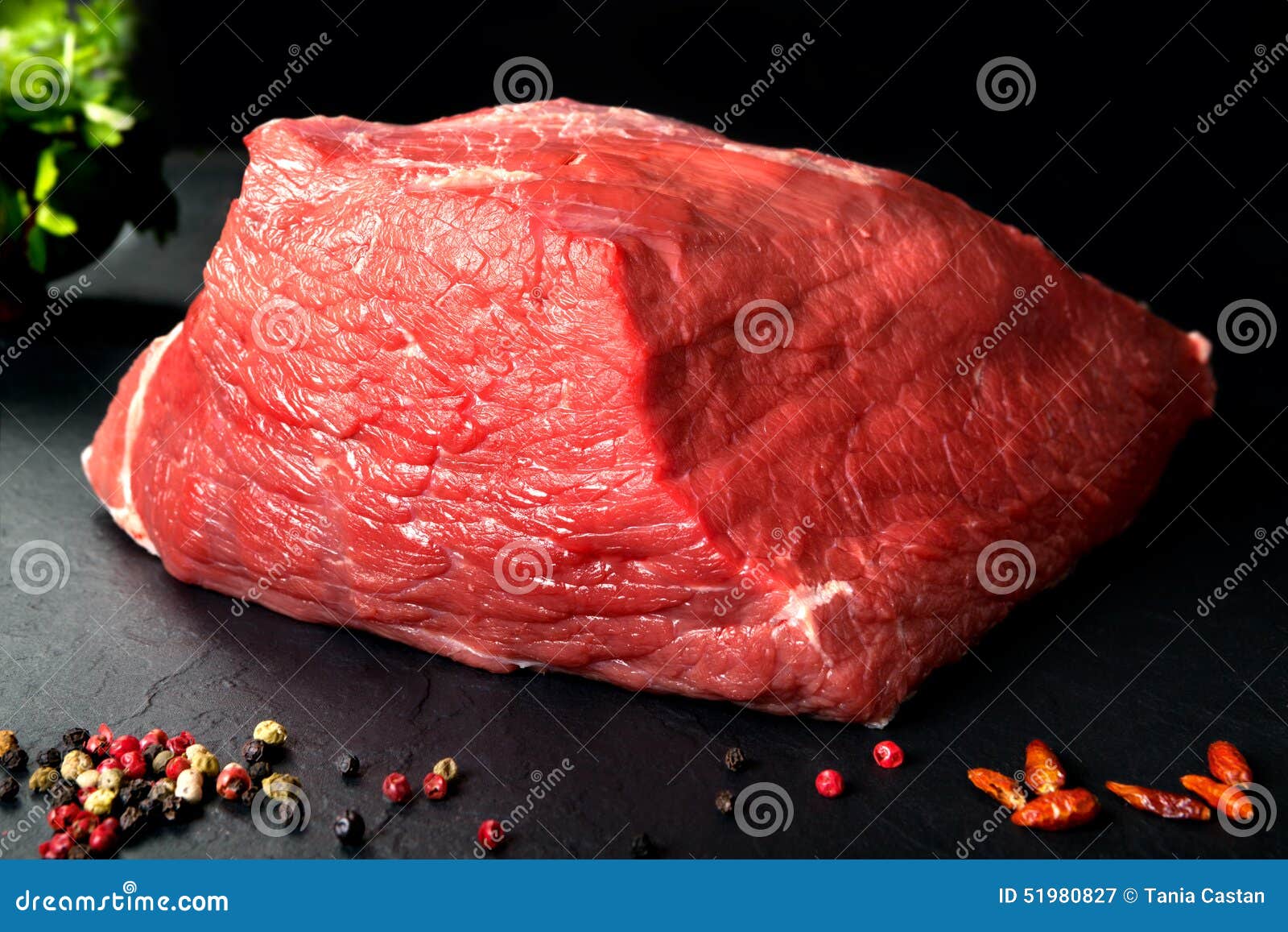 uncooked fresh pork and beef. raw red meat with black stone background and spices