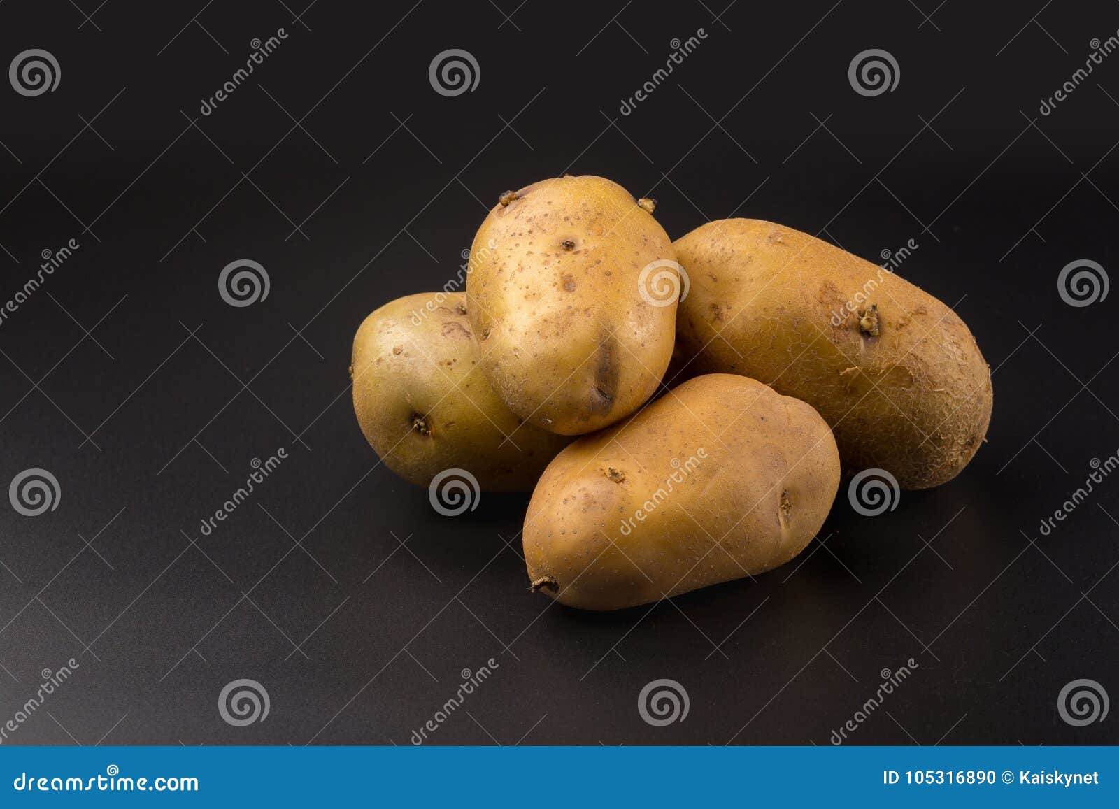 Uncooked Fresh Potatoes Isolated on a Black Background Stock Photo