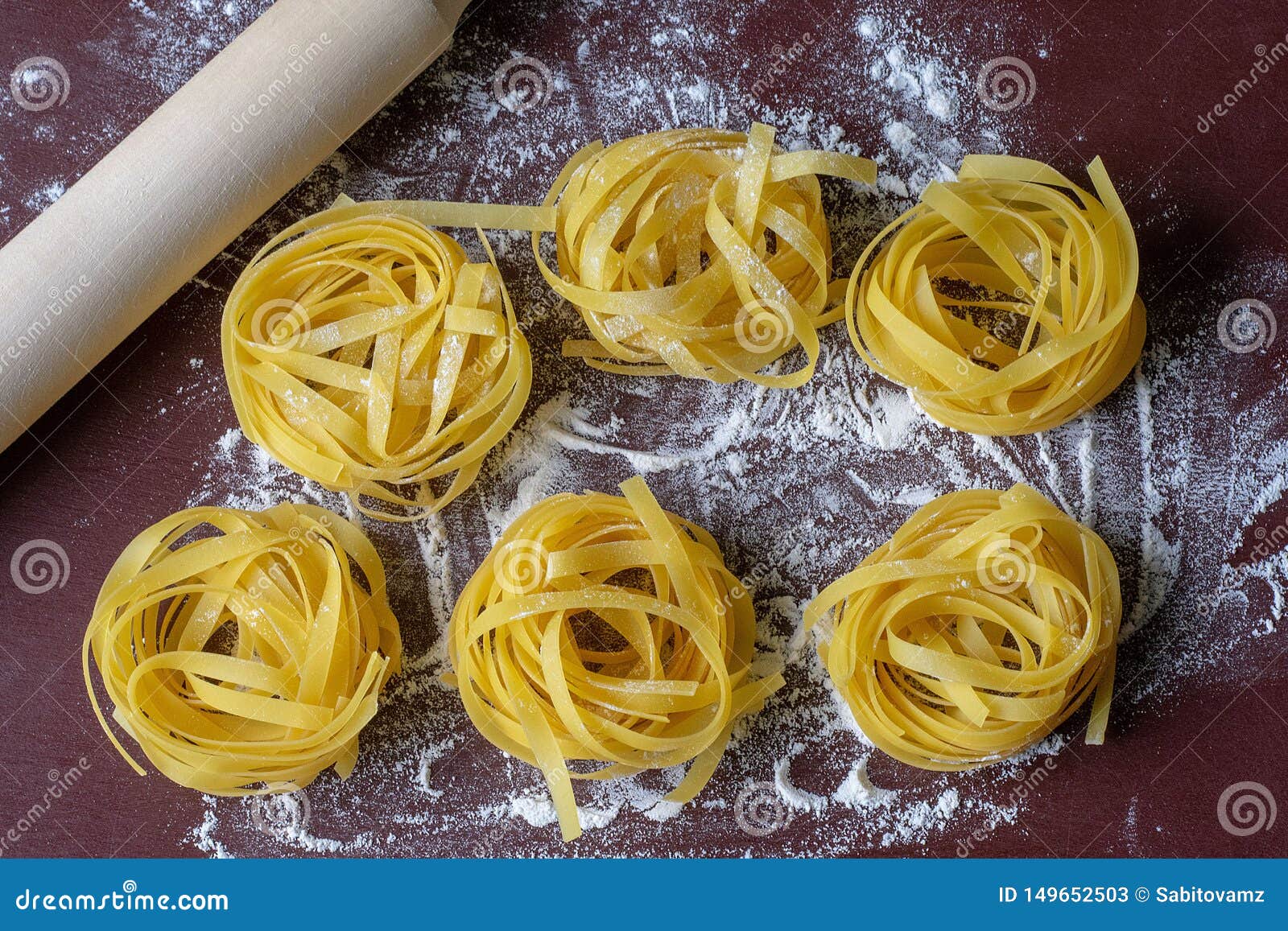 Uncooked Pasta on a Dark Background, Sprinkled with Flour, Near the Rolling Pin Stock Image
