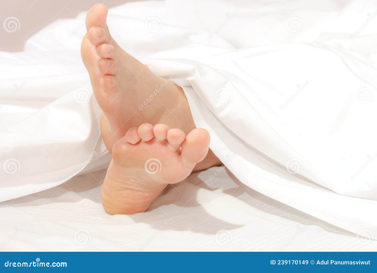 Under the Covers with Feet Showing in a Bed. Stock Image Image of