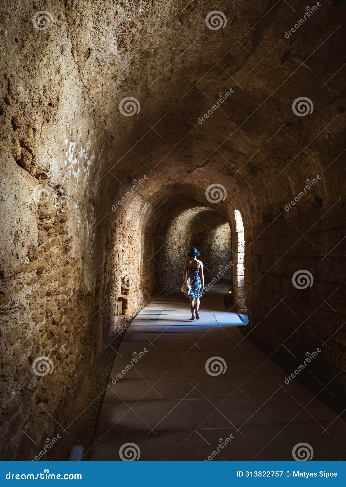 underground tunnel at the roman theatre of cÃÂ¡diz with a young woman in sundress walking through