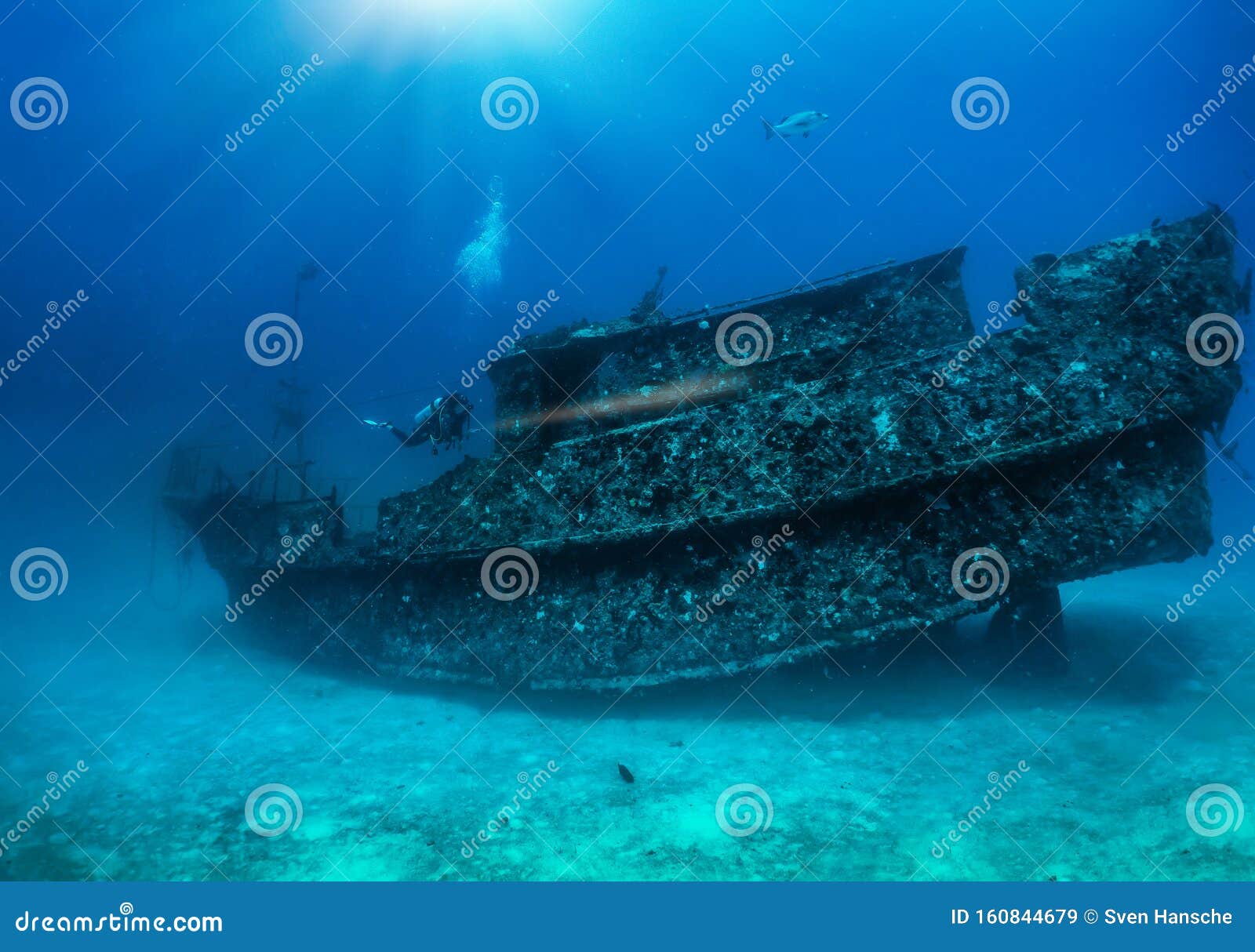 scuba diver exploring a sunken shipwreck at the maldives islands, indian ocean