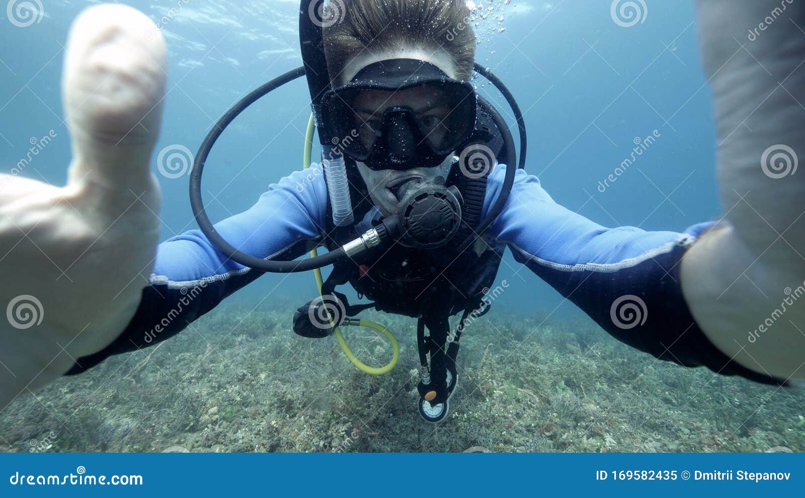 underwater selfie photo of a male suba diver in the blue ocean.