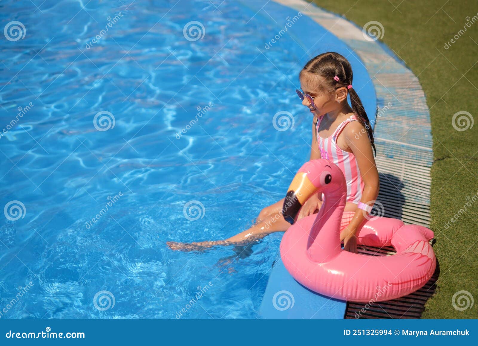 Une Belle Petite Fille En Maillot Rose Rayé Est Assise Au Bord De