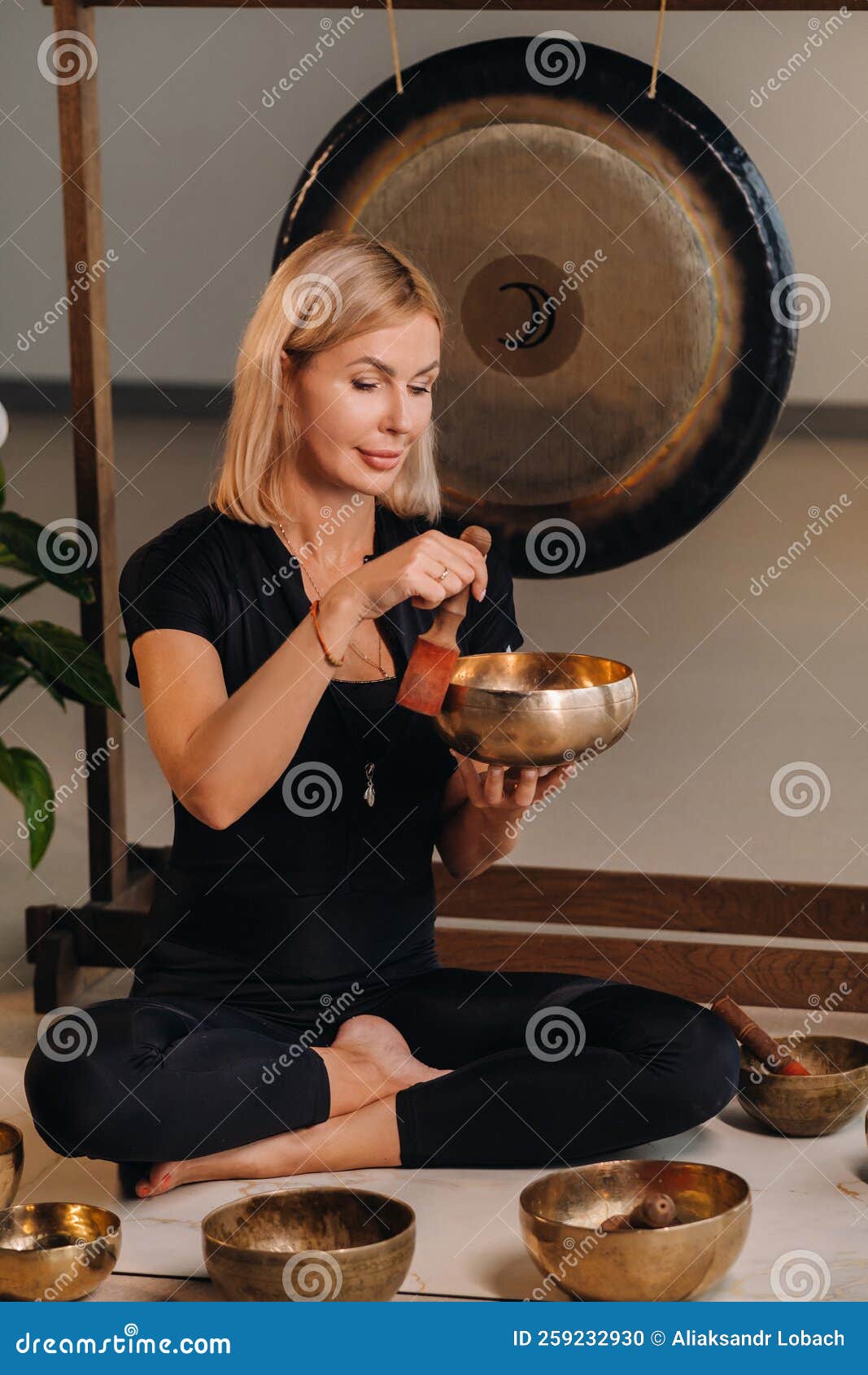 Une Femme Joue Un Bol De Chant Tibétain Assis Sur Un Tapis De Yoga à  L'arrière D'un Gong Photo stock - Image du népal, bouddhisme: 259232930