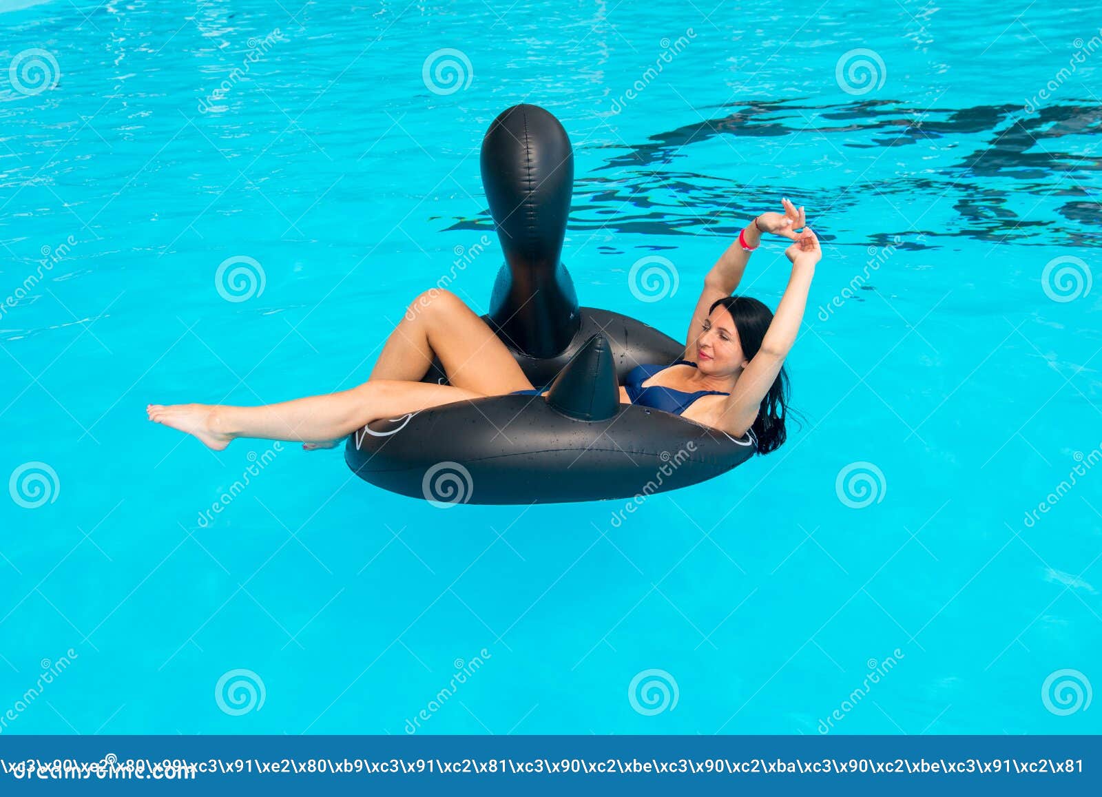 Une femme assise sur une bouée de sauvetage dans une piscine photo