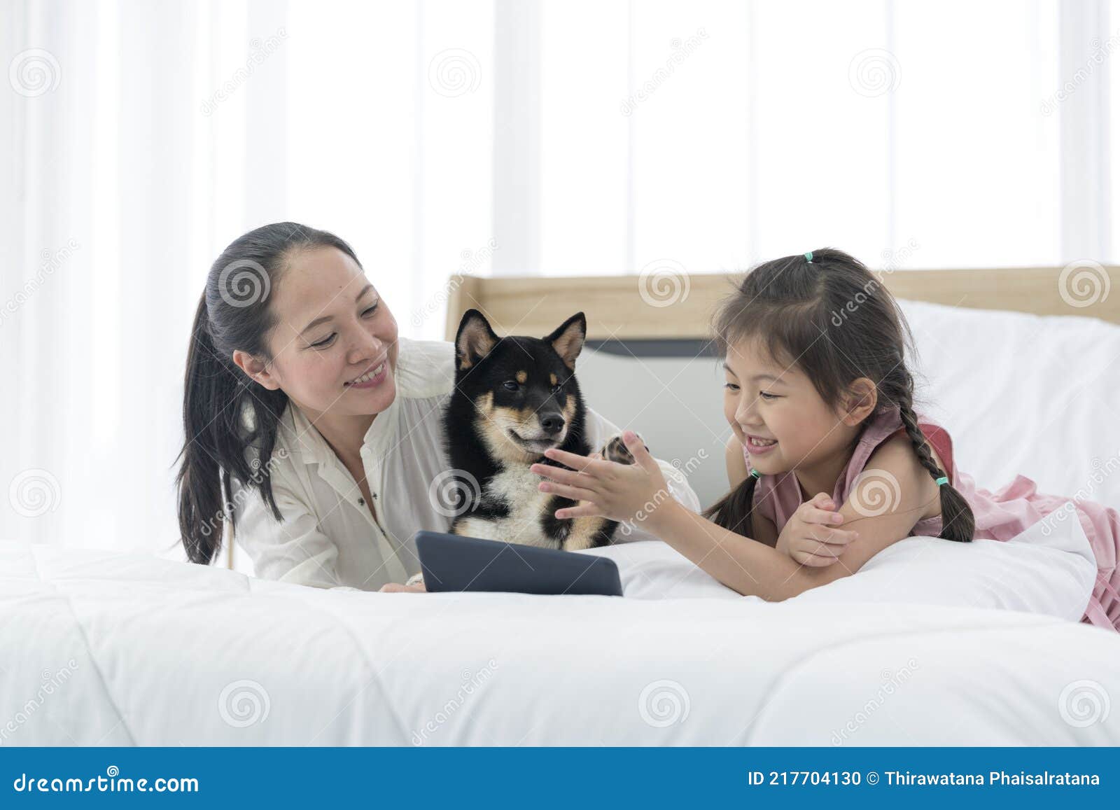 Une Fille Asiatique Avec Sa Mère Est Assise Sur Un Lit Avec Un 