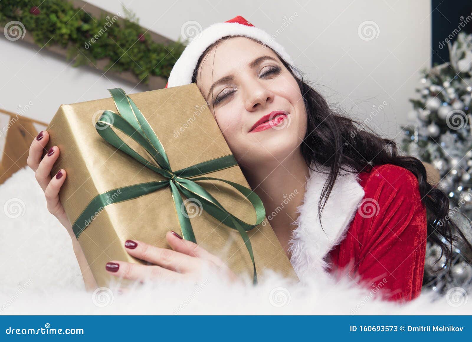 Une Fille Embrasse Un Cadeau Allongé Sur Le Lit Jeune Femme Vêtue De La  Tenue Du Père Noël, Cadeau De Noël Ou De La Nouvelle Anné Image stock -  Image du noël