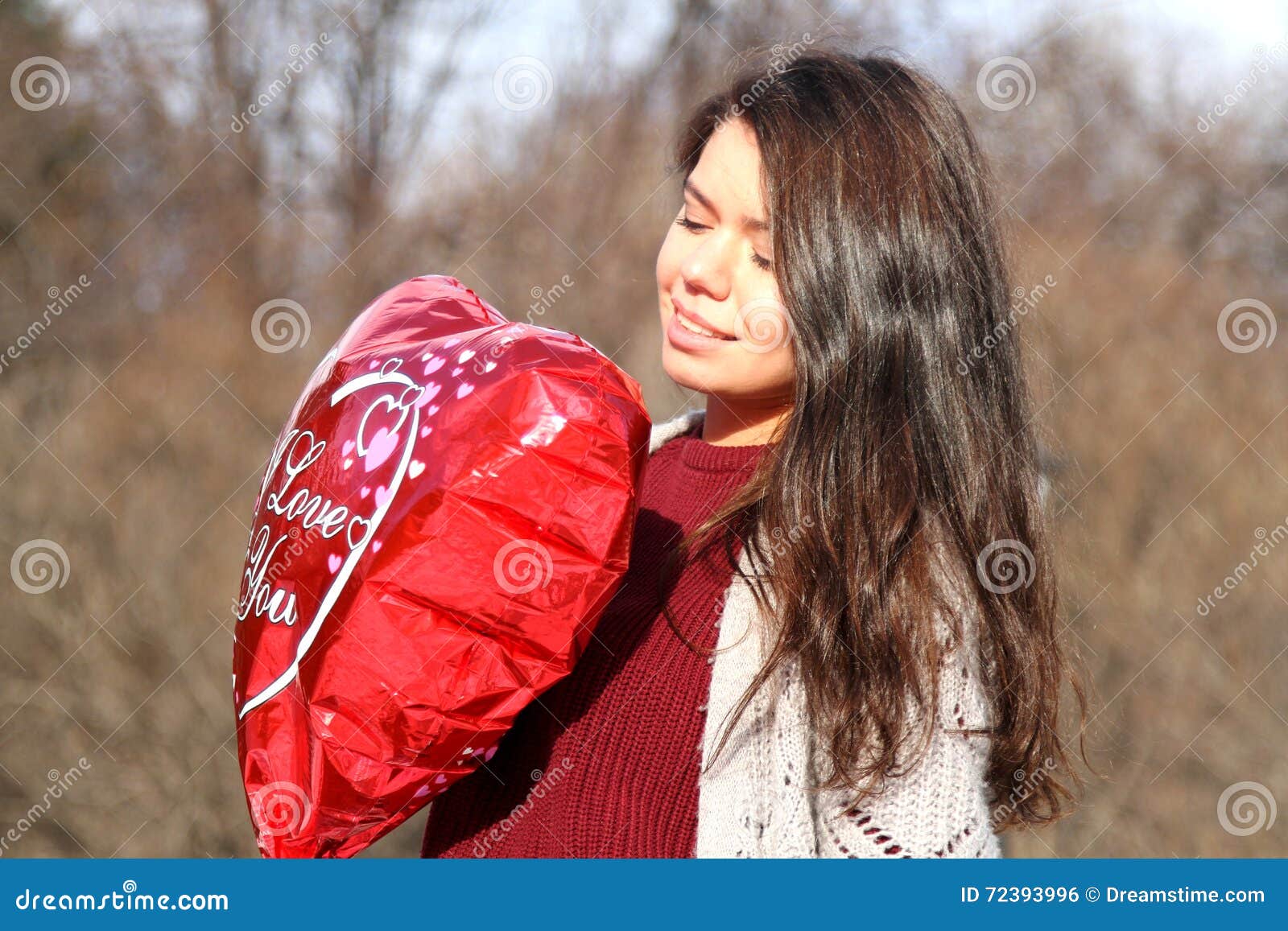 Une fille tenant un ballon sous forme de coeur. Fille souriant et tenant un ballon sous forme de coeur