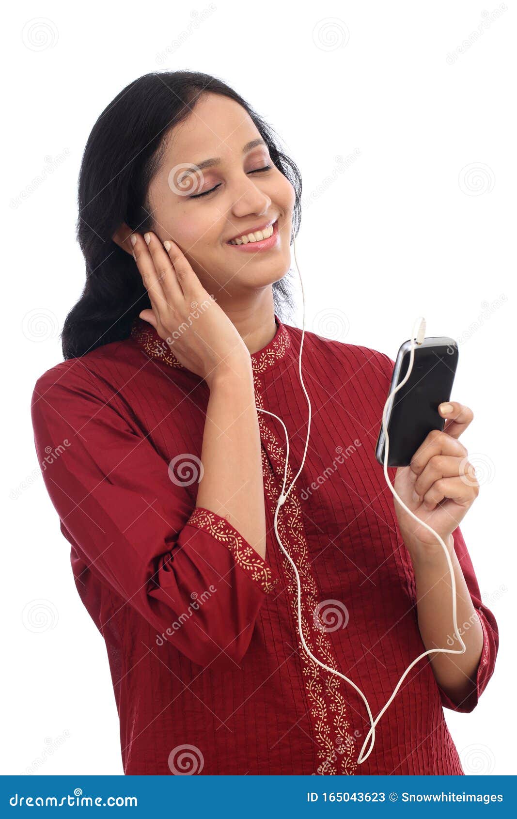 Une jeune femme heureuse jouant de la musique avec un smartphone contre le blanc