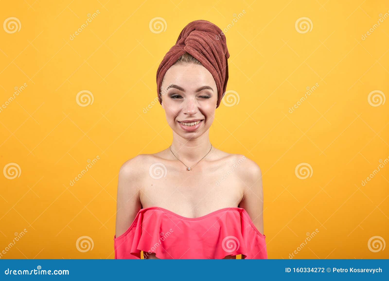 Une Jeune Fille Avec Une Serviette Sur La Tête Sur Un Fond Orange Isolé Montre Des émotions 