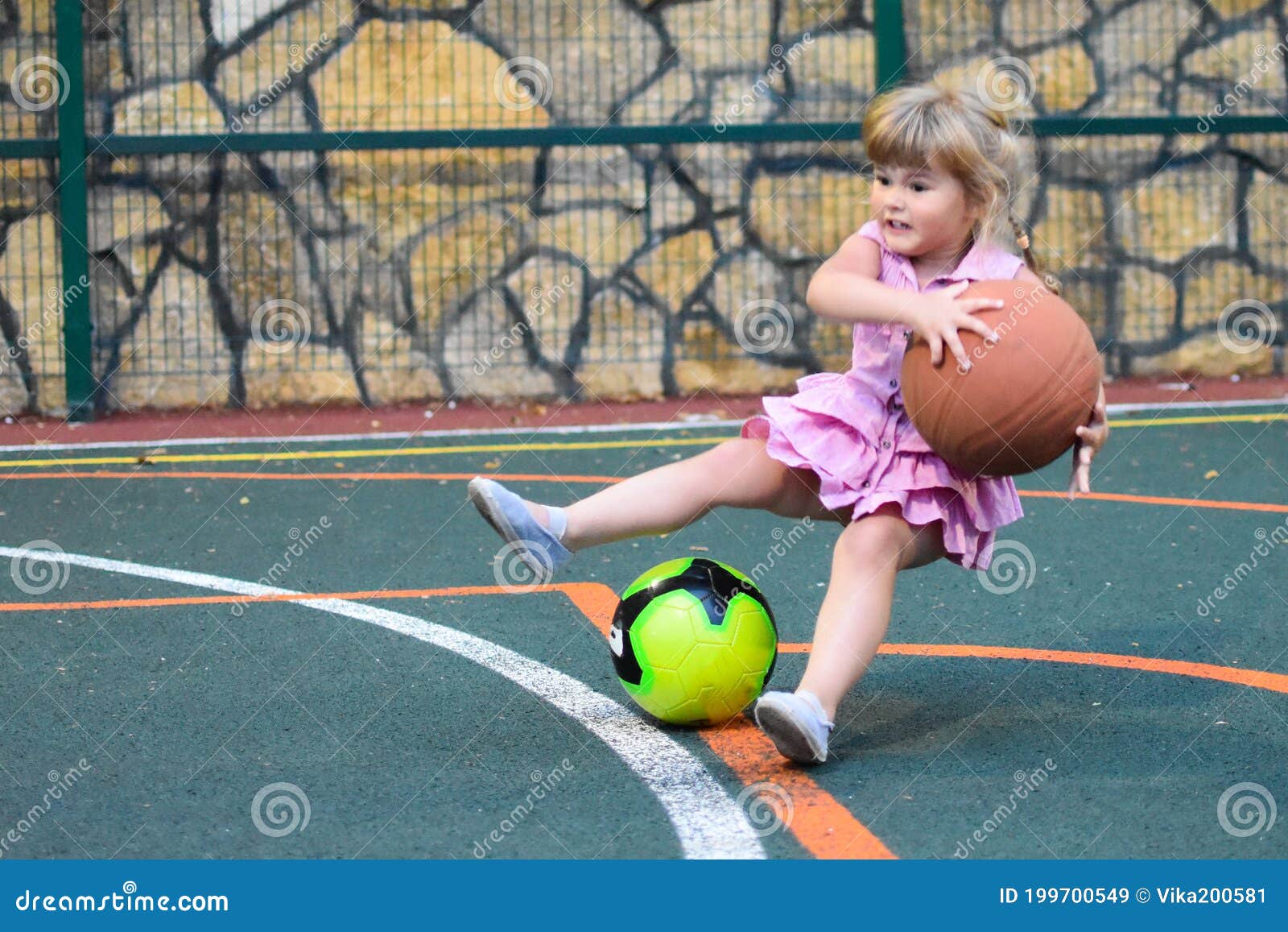 Une Petite Fille Tombe Avec Une Balle Sur Le Terrain De Sport Un Enfant  Avec Un Grand Basket Image stock - Image du heureux, stationnement:  199700549