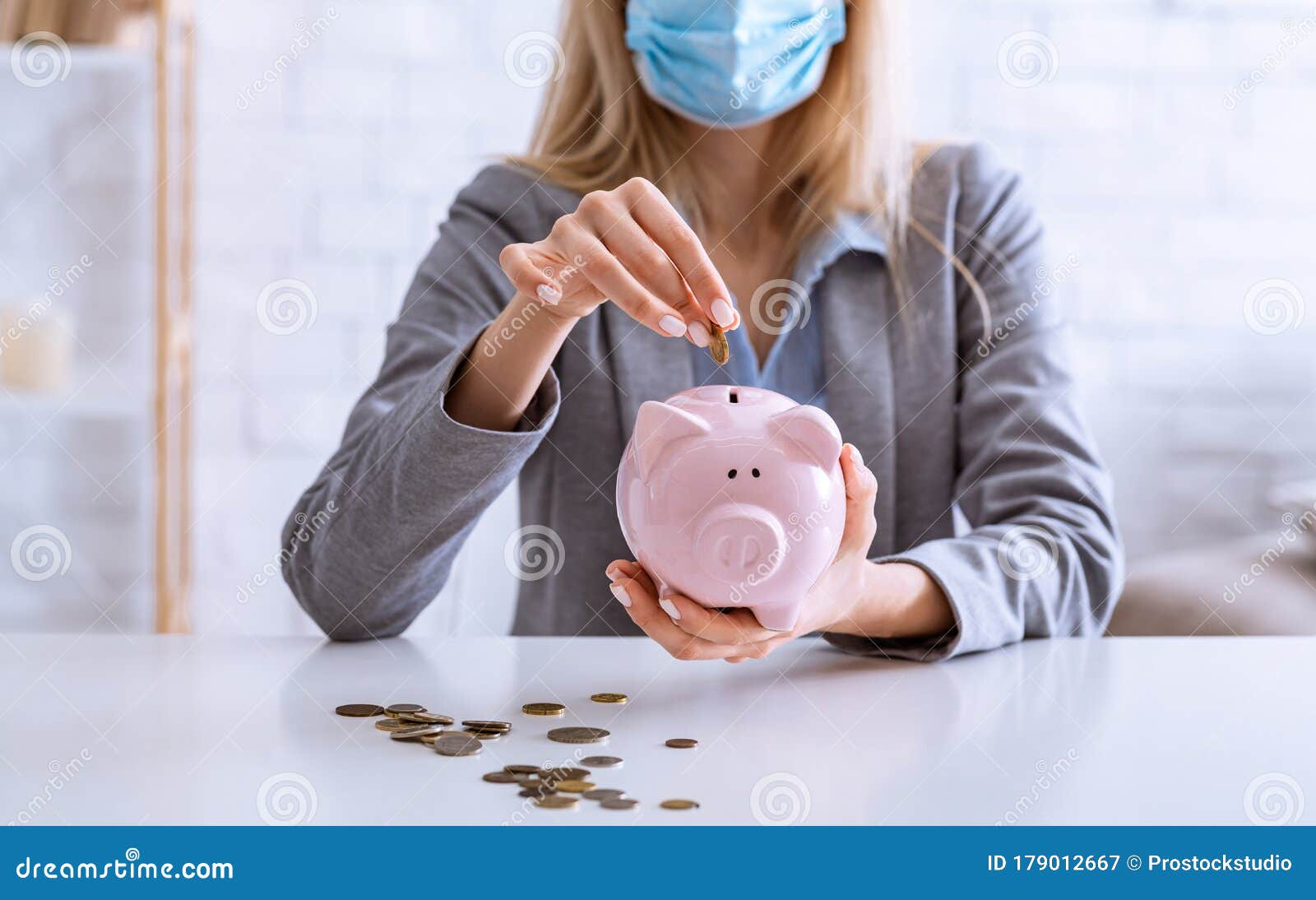 unemployment during epidemic. woman puts coins into piggy bank