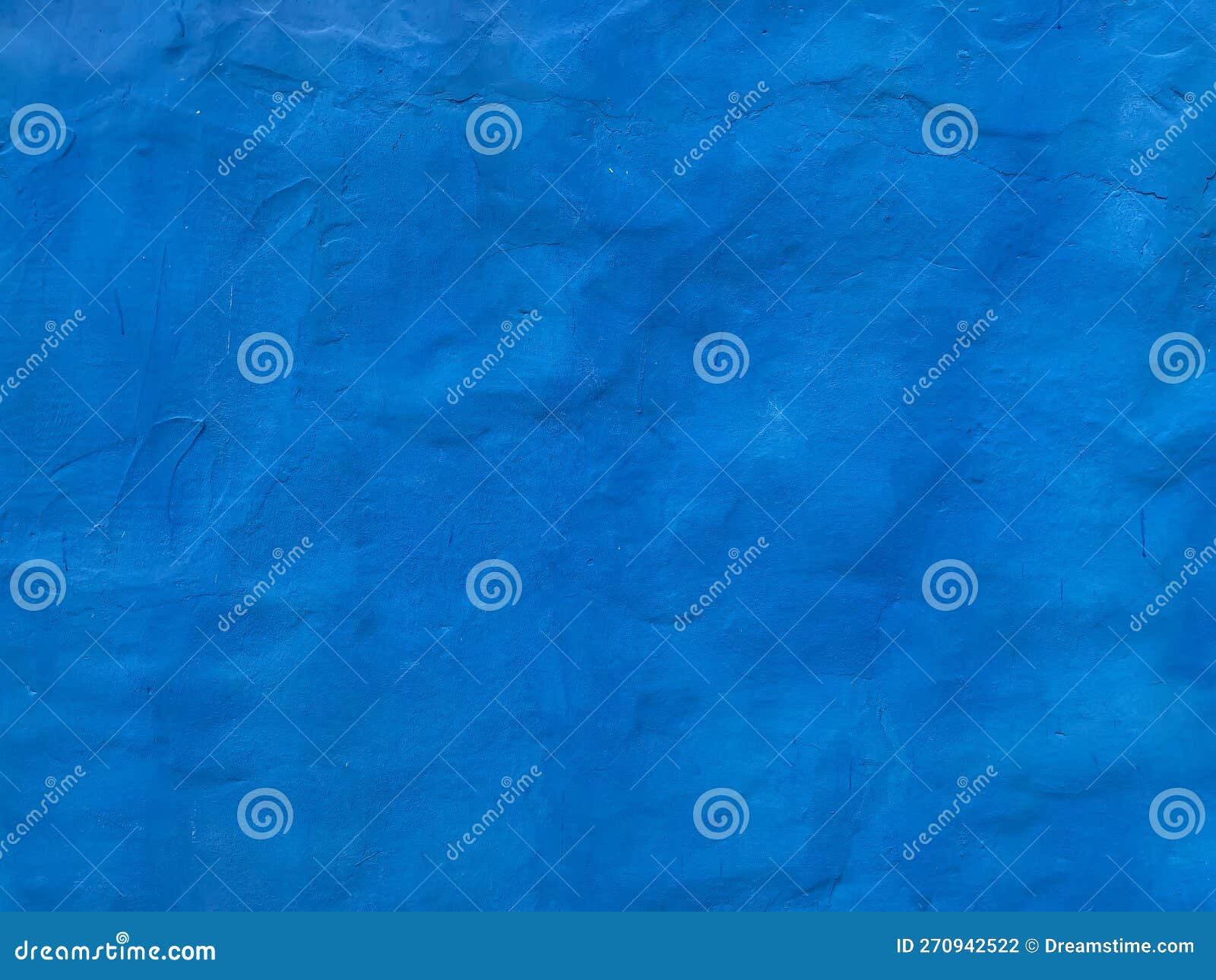 Uneven Blue Wall with Blue Paint Plaster As a Background Stock Photo