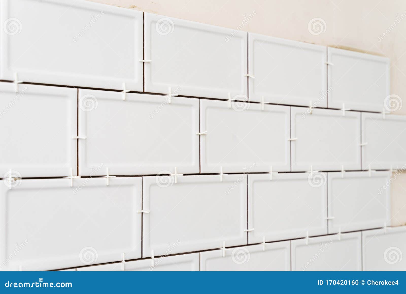 Unfinished White Ceramic Tiles with Tile Spacers. Concept of a Kitchen