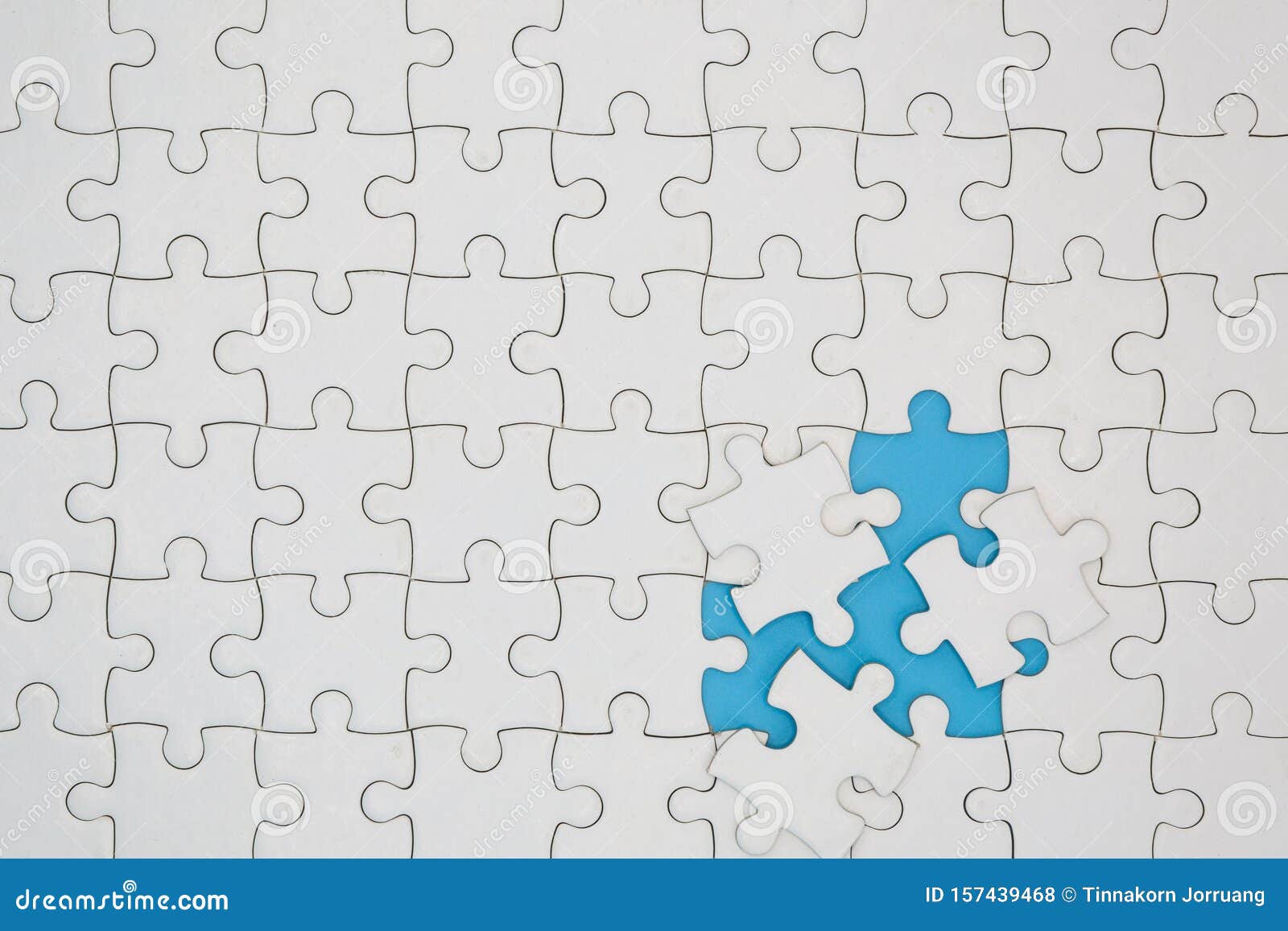 unfinished white jigsaw puzzle pieces on blue background, the last piece of jigsaw puzzle, copy space