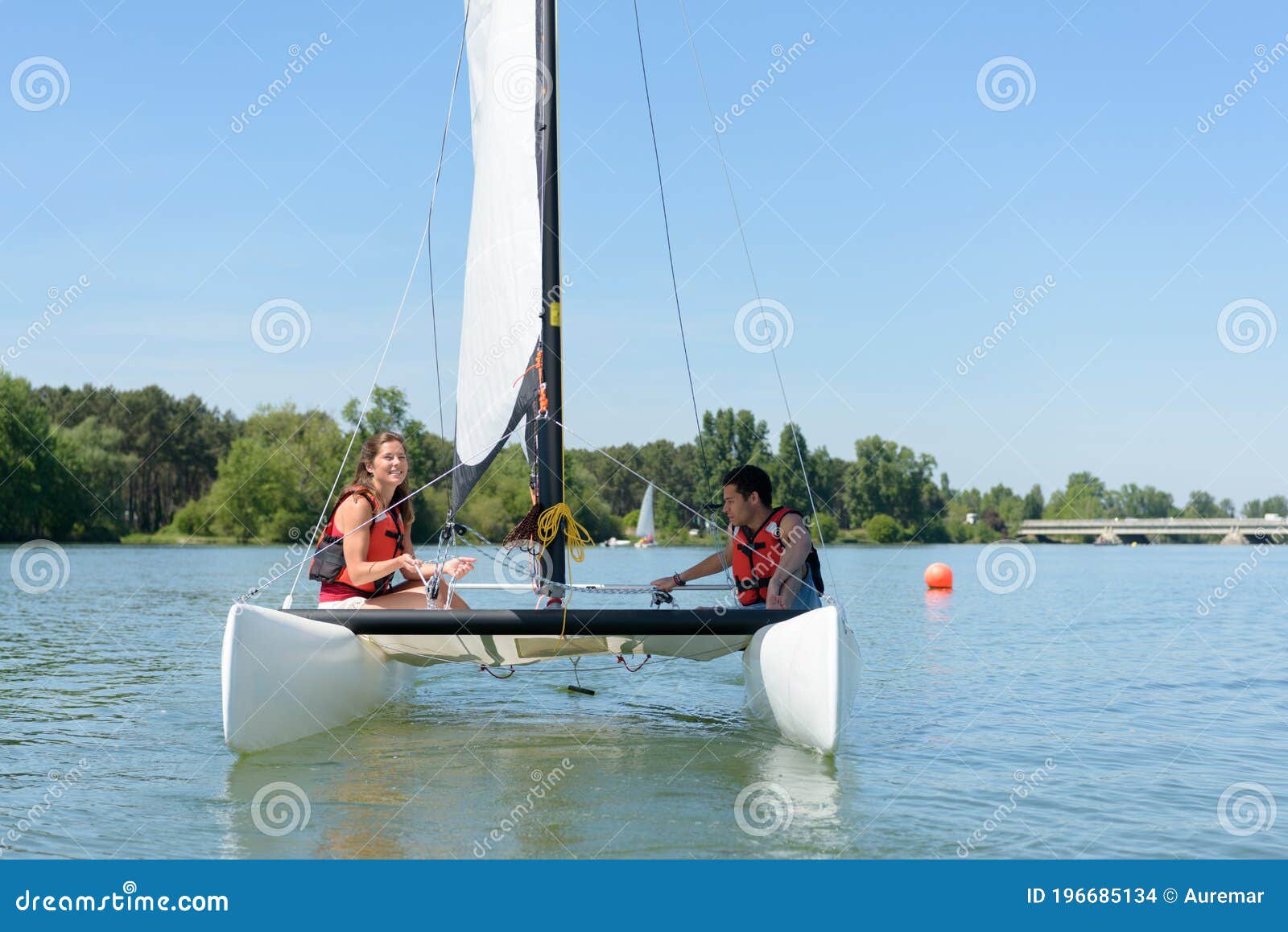 Unga par som rekreerar segelbåt på segelbåt. Unga par som rekreationsseglar på små segelbåtar