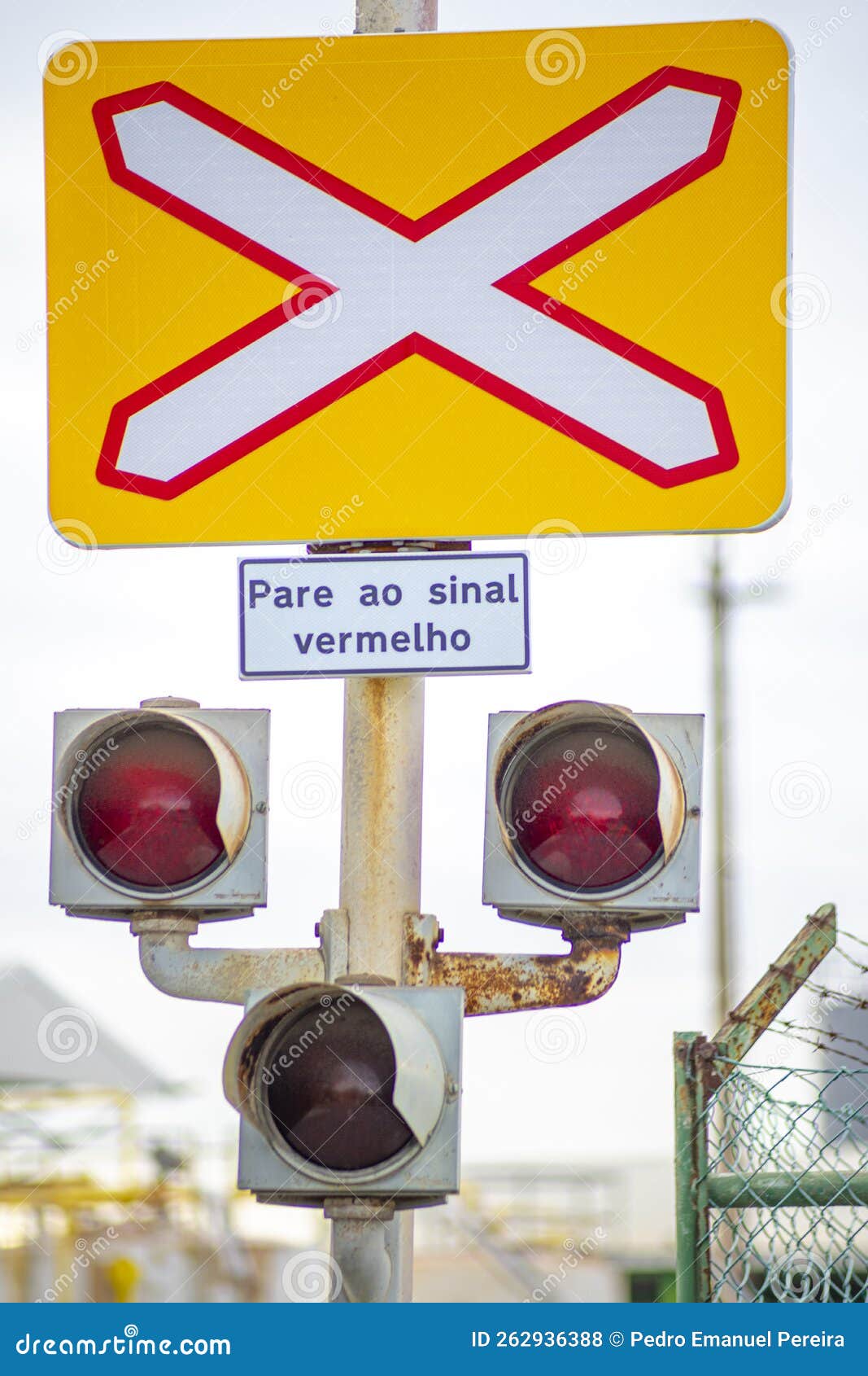 unguarded level crossing traffic sign for trains.  3 traffic lights.  information panel, "pare ao sinal vermelho"