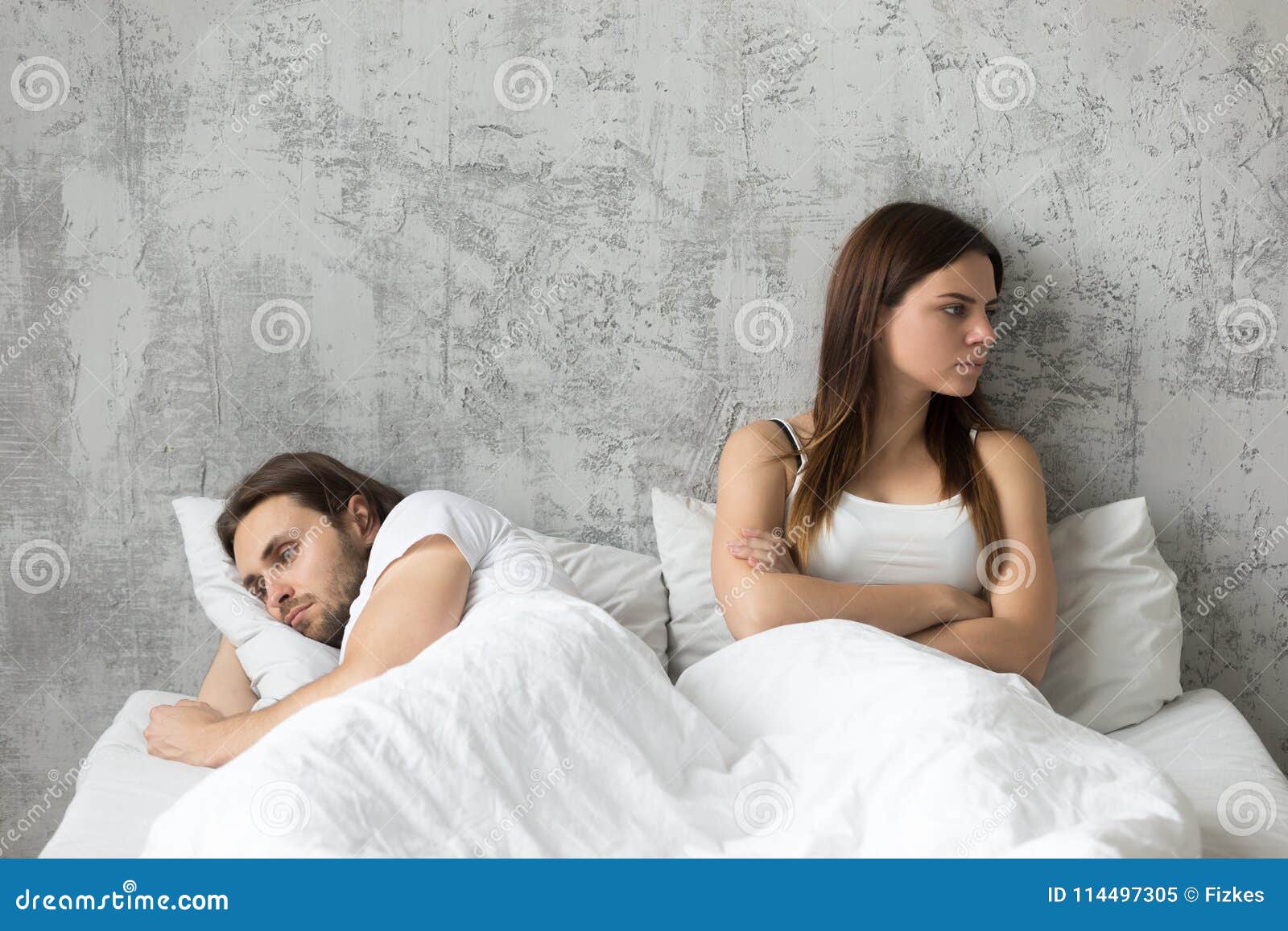 unhappy sad couple after quarrel ignoring each other in bed