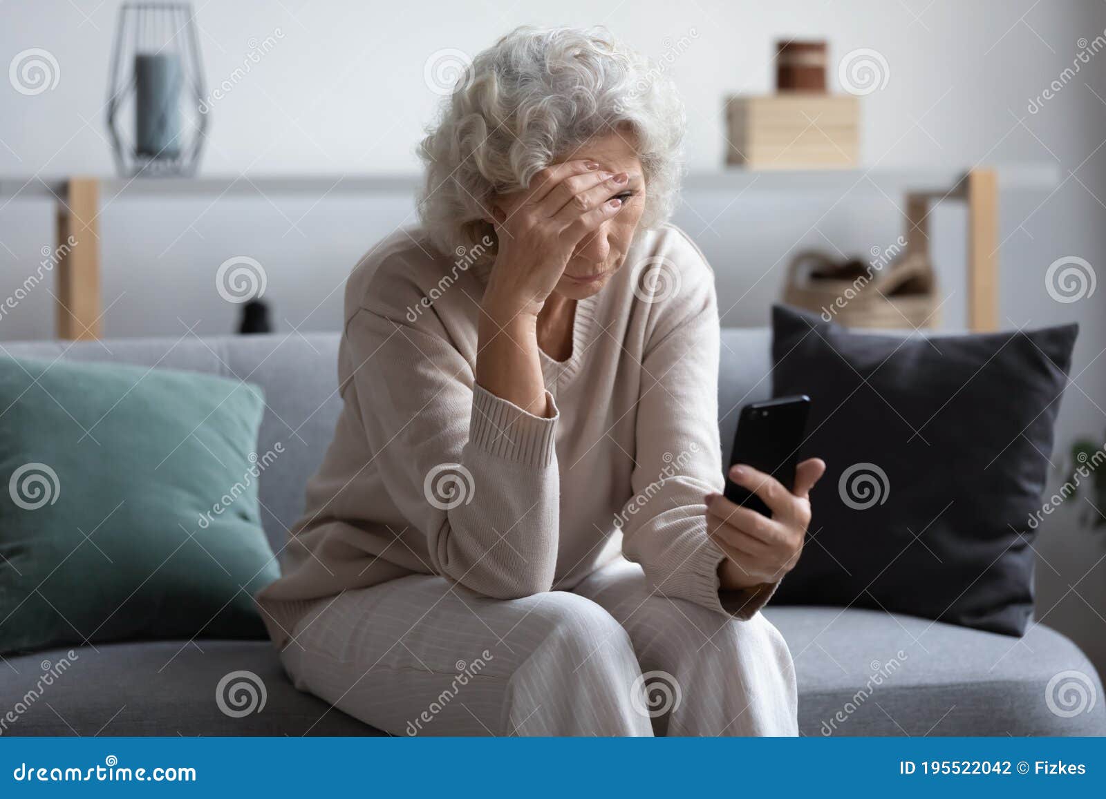 unhappy stressed mature middle aged woman looking at phone screen