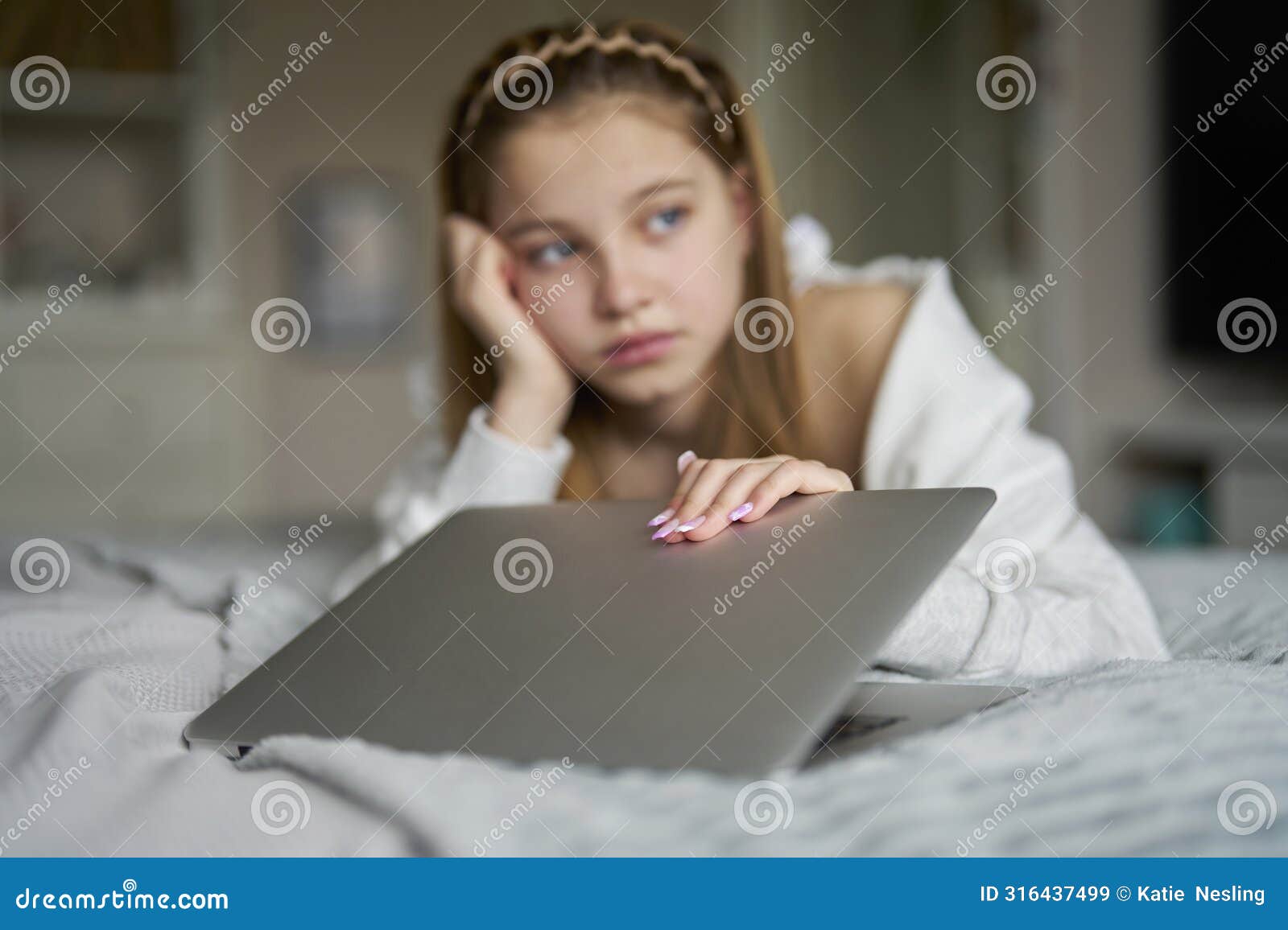 unhappy teenage girl closing laptop lying on bed at home anxious about social media online bullying