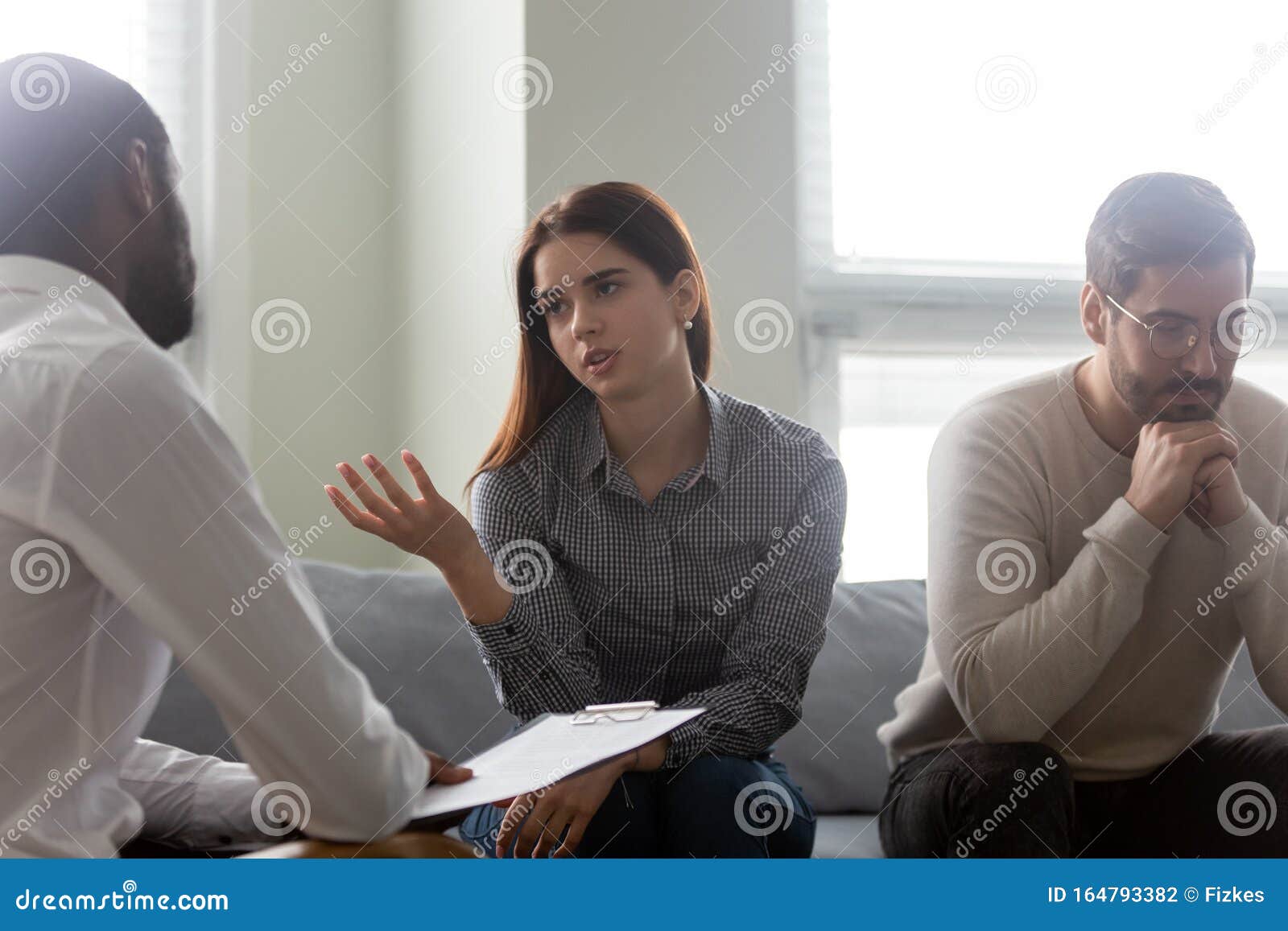 unhappy wife talking with male counselor at family therapy session