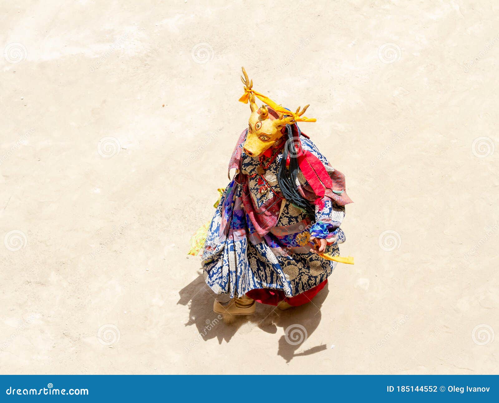 monk in deer mask performs a religious masked and costumed mystery dance of tibetan buddhism on the cham dance festival