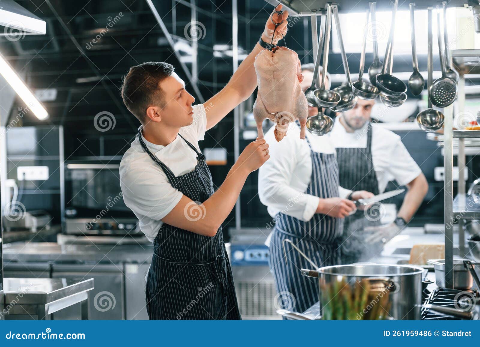 In Uniform. Kitchen Workers is Together Preparing the Food Stock Photo