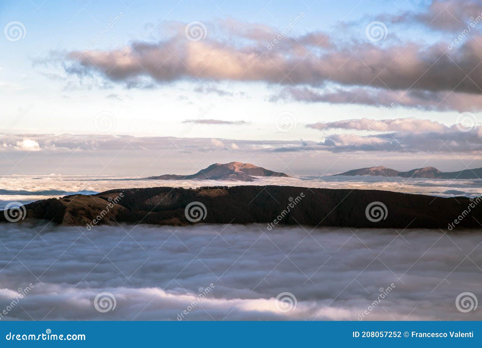 aerial view of mountains surrounded by clouds at magical sunset, italy