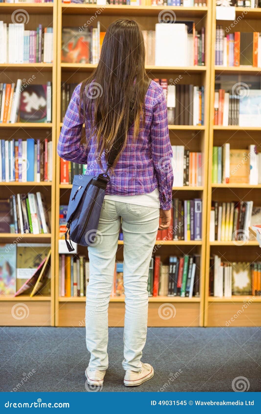 university student standing in the bookcase