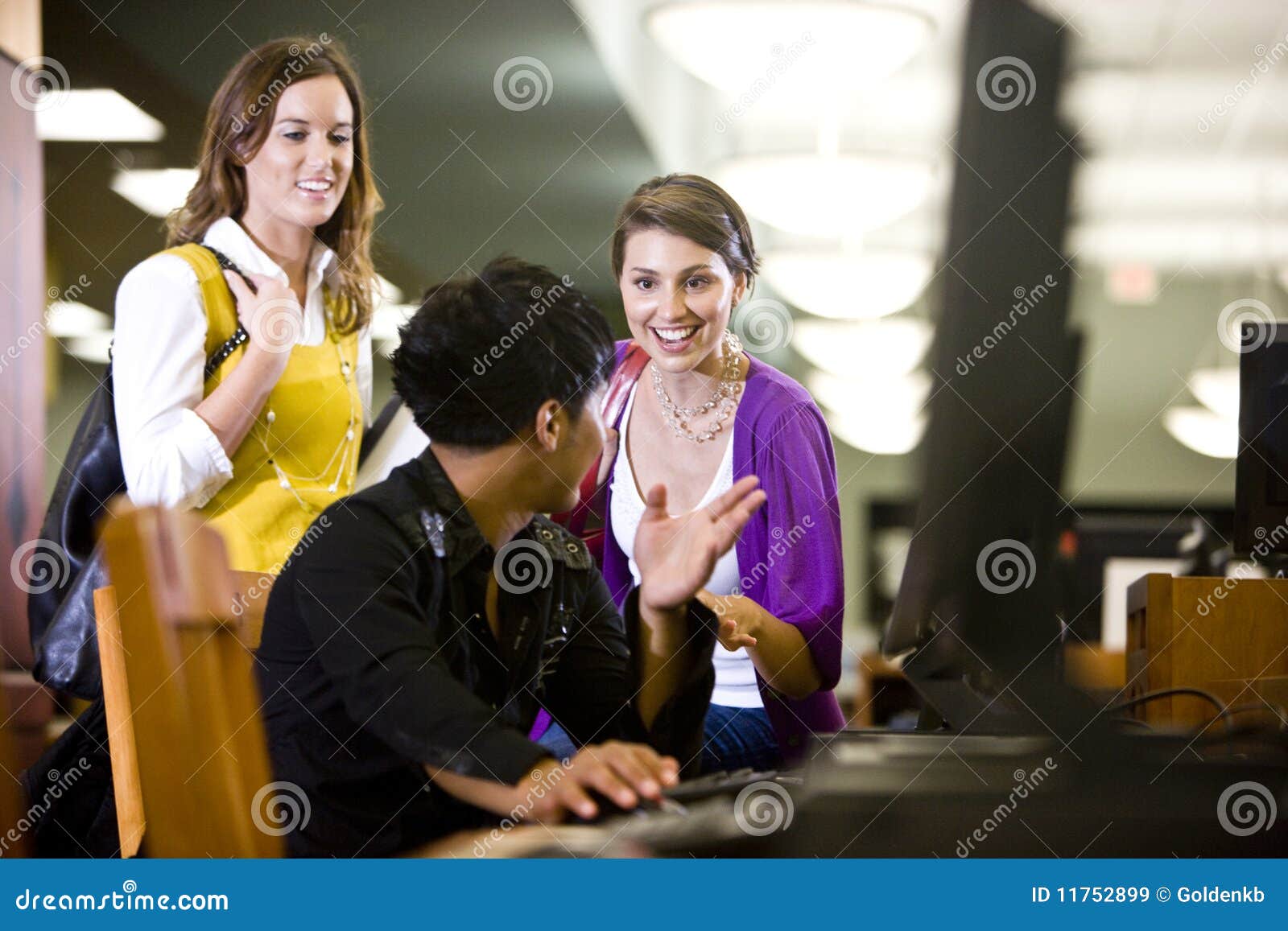 university students conversing by library computer