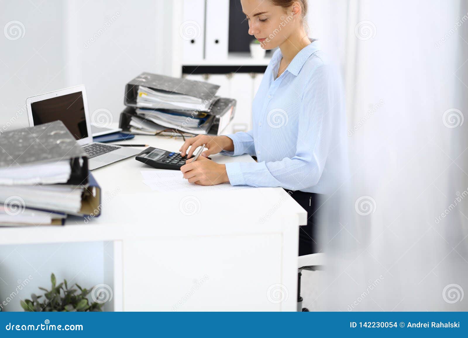 unknown female bookkeeper or financial inspector calculating or checking balance, making report, close-up. internal