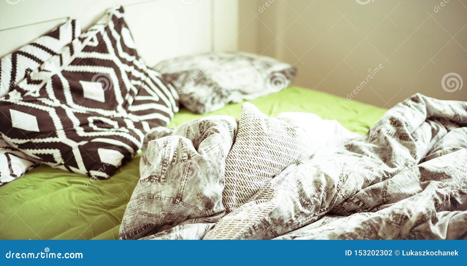 An Unmade Bed with Linens and Green Sheet Stock Photo Image of bright