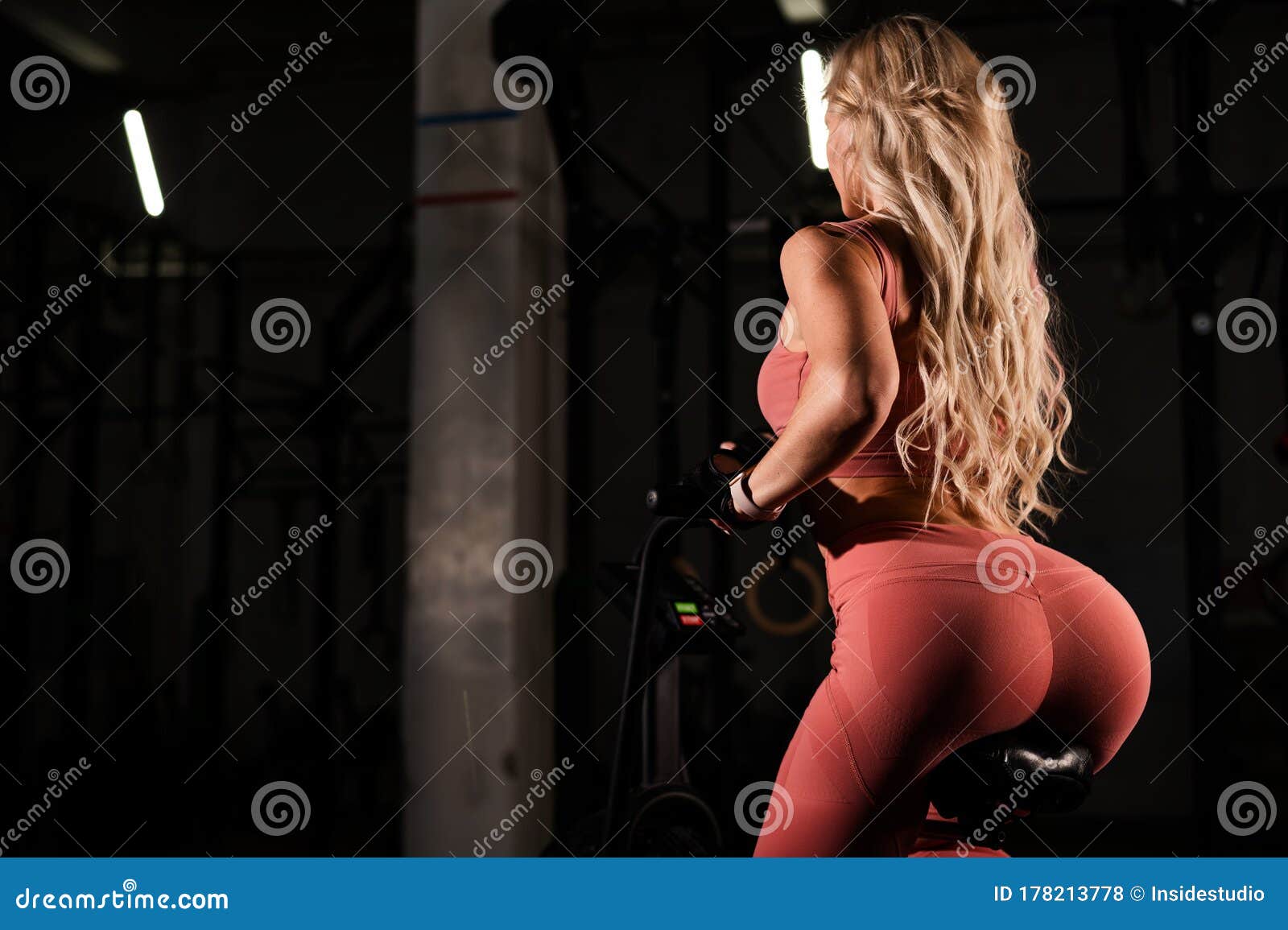 Unrecognizable Blonde With Elastic Buttocks Is Training In An Air Bike