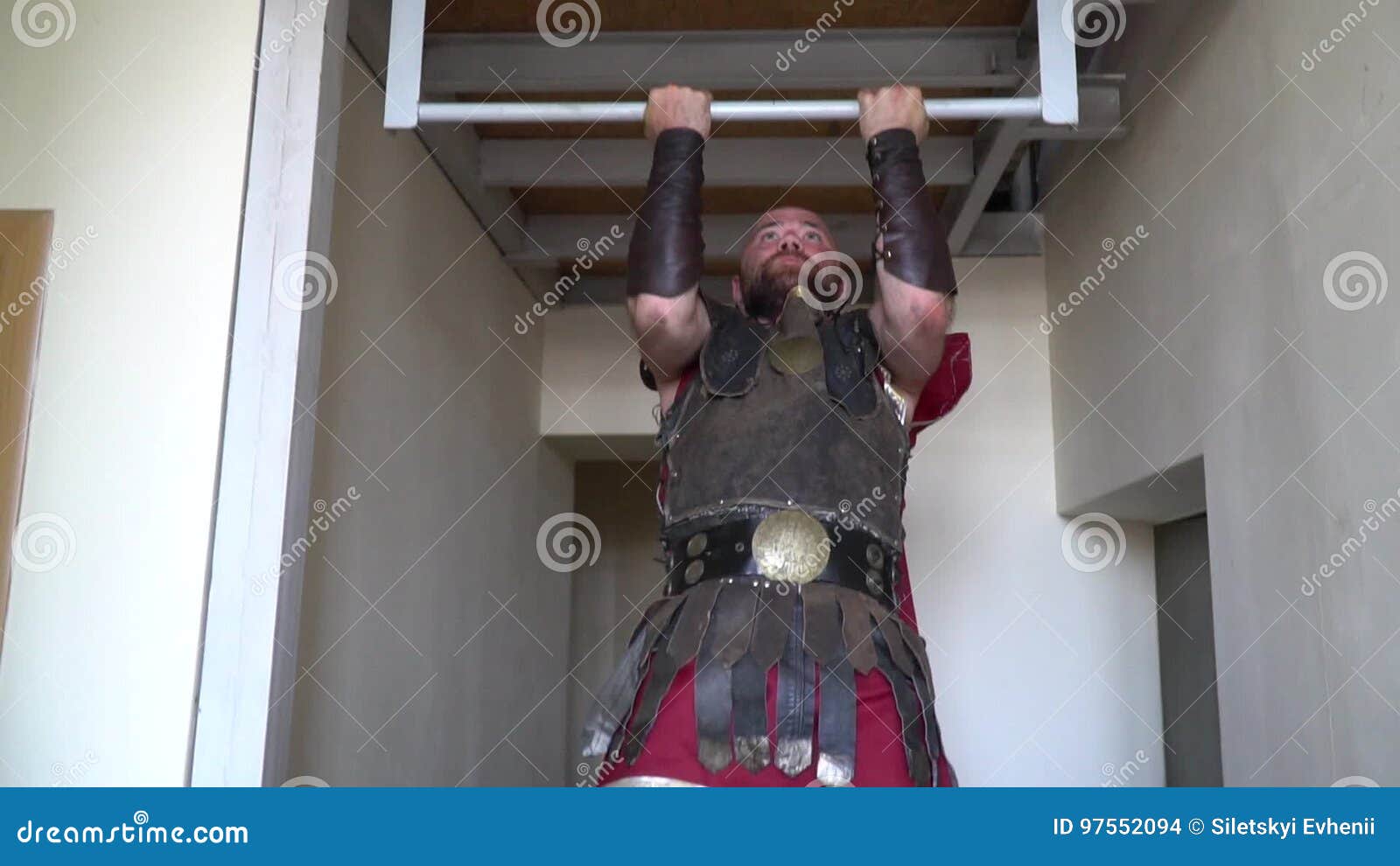 Unshaven Roman Gladiator In Leather Armor Pulls Up On A Horizontal